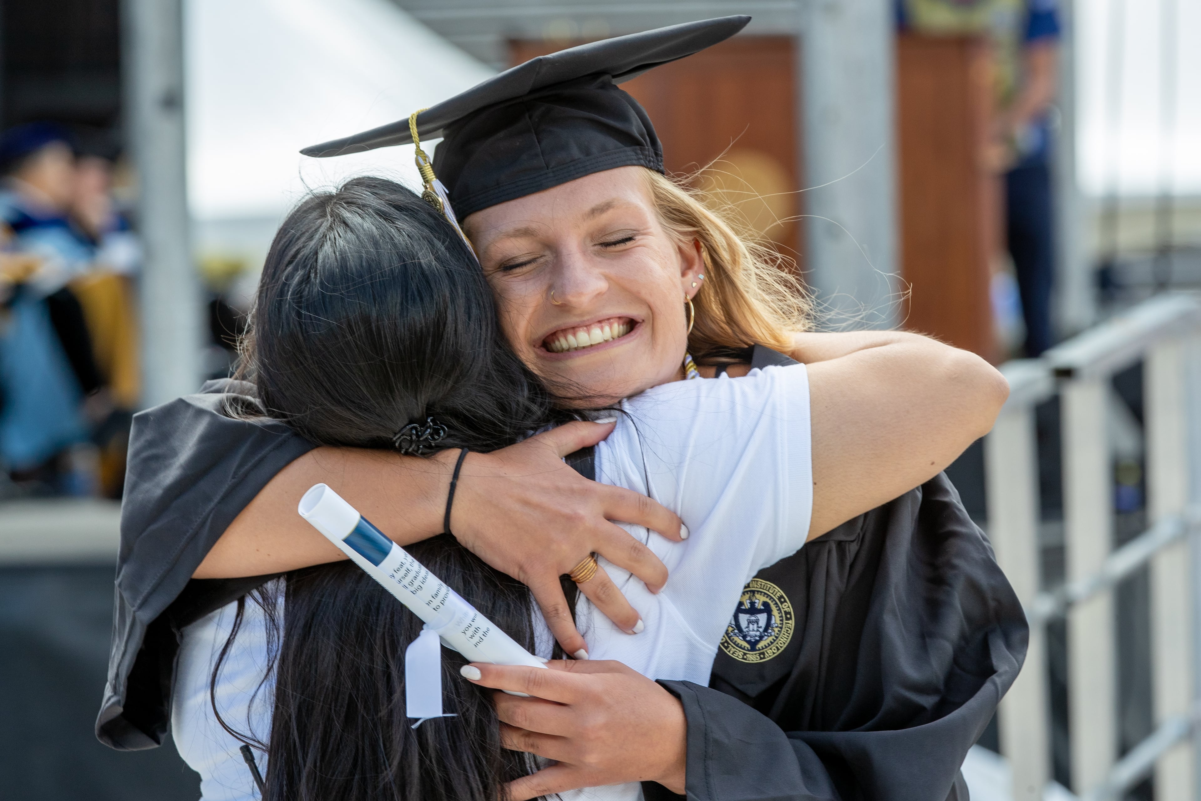 Lindsay Shurtz gets a hug from a friend after receiving her diploma during the Georgia Institute of Technology's afternoon Commencement Ceremony at Bobby Dodd Stadium on Saturday, May 7, 2022. (Steve Schaefer / steve.schaefer@ajc.com)