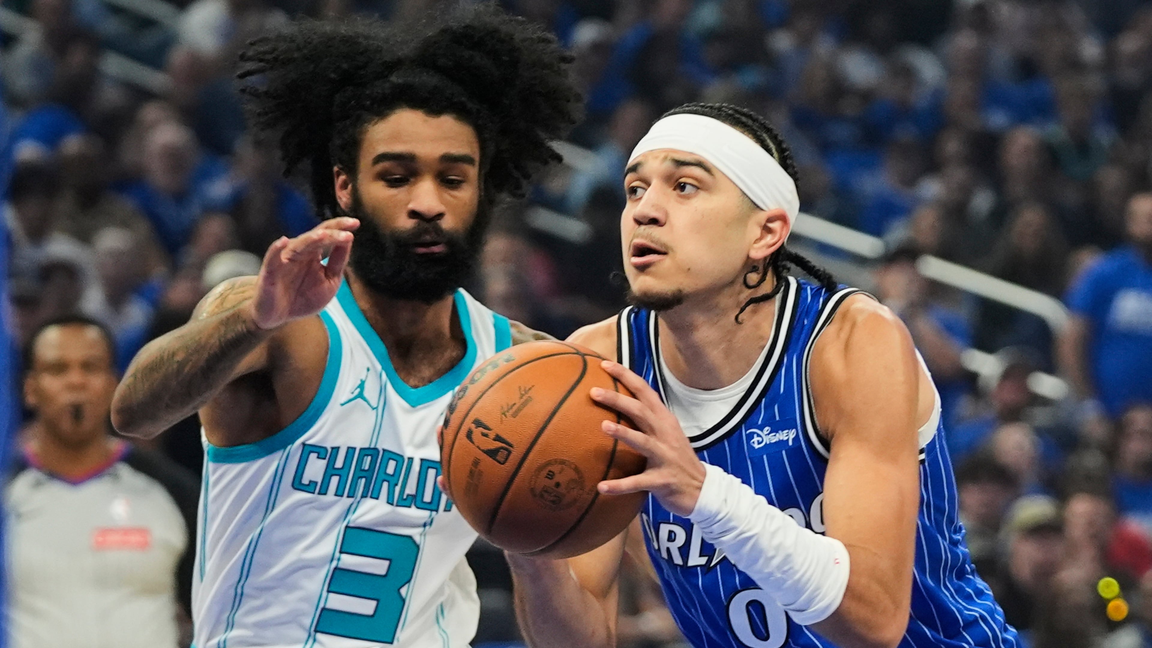 Orlando Magic guard Anthony Black (0) drives around Charlotte Hornets guard Coby White (3) during the first half of an NBA play-in tournament basketball game, Friday, April 17, 2026, in Orlando, Fla. (AP Photo/John Raoux)