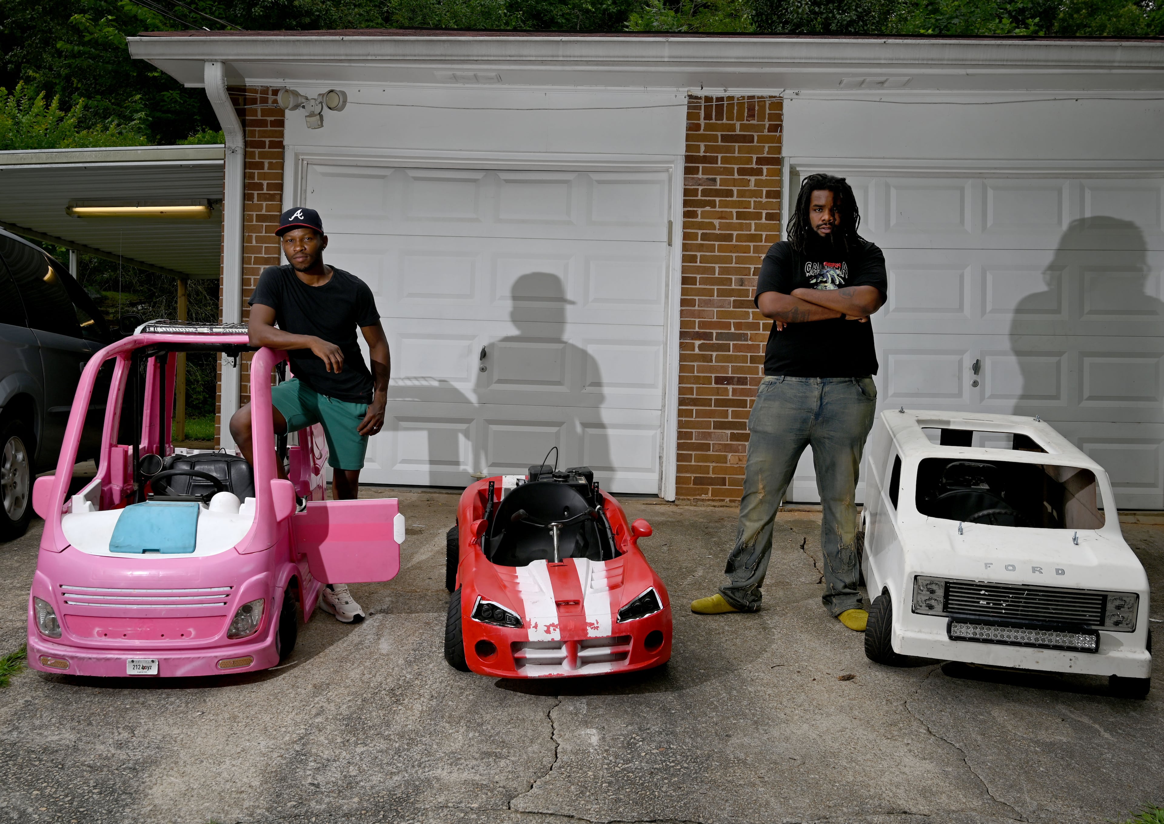 Mali “Sota” Hightower (left) and Marvelous Garvey modify kids' cars into gas-powered minicars in Ellenwood. The Barbie camper is the eighth in a collection. (Hyosub Shin/AJC)