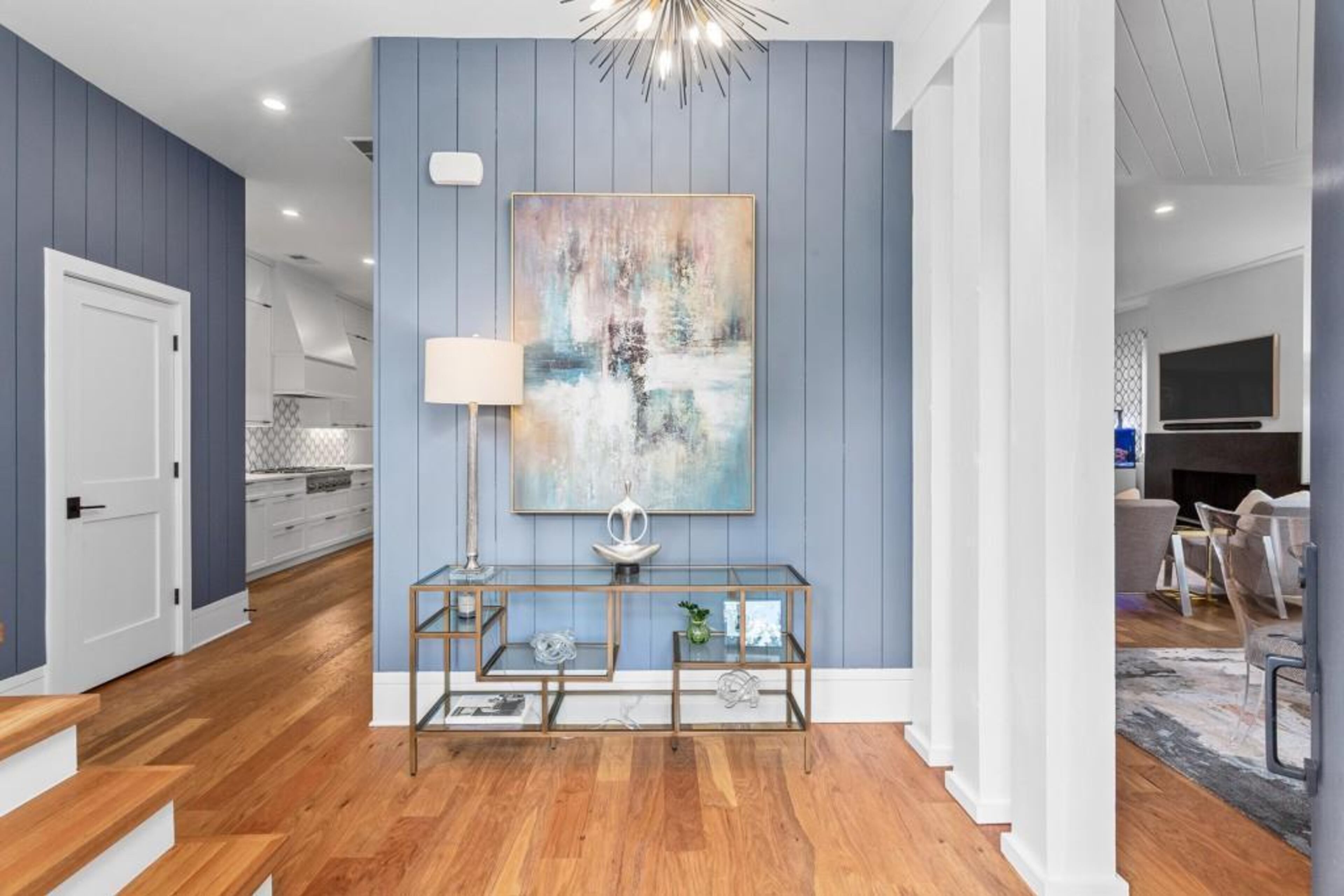 Guests are greeted by oversized wraparound front porch with two sets of French doors leading to gracious foyer featuring shiplap accent wall and gorgeous hardwood floors.