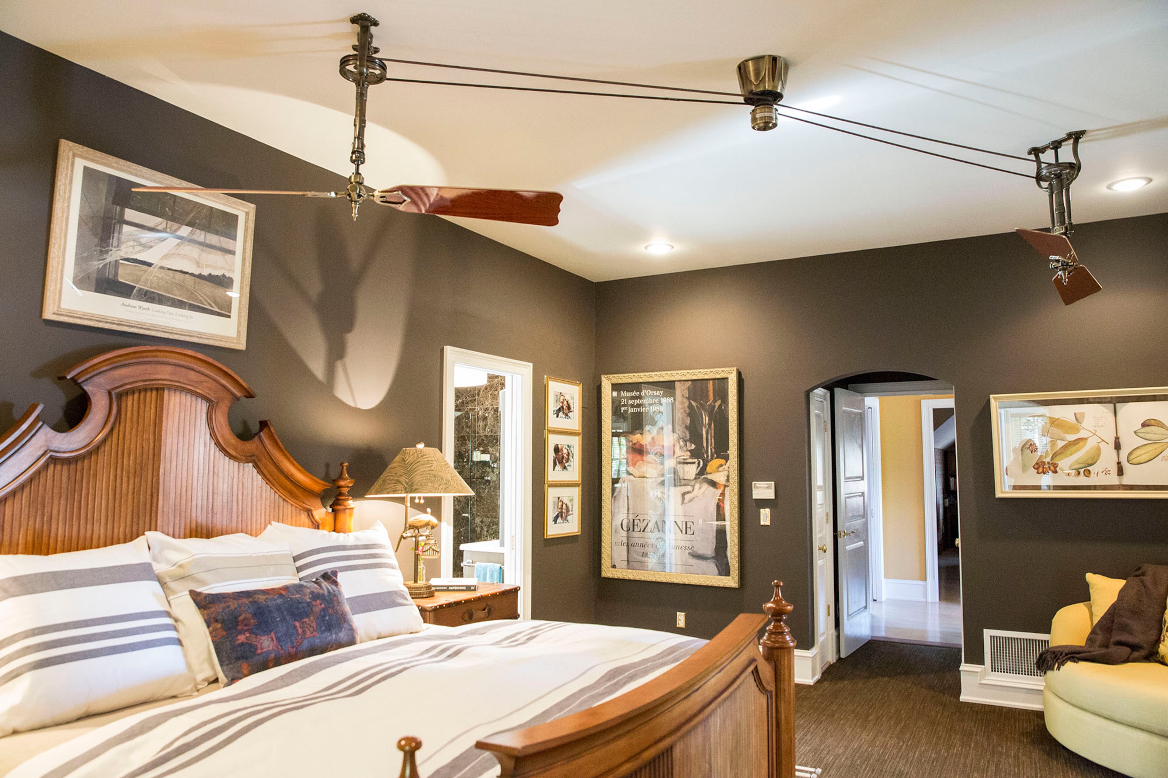 In the master suite, a Fanimation fan draws the eye upward and outward. The bed, from High Point, N.C., is completed with Libeco Belgian linens from Lewis and Sheron Textiles.