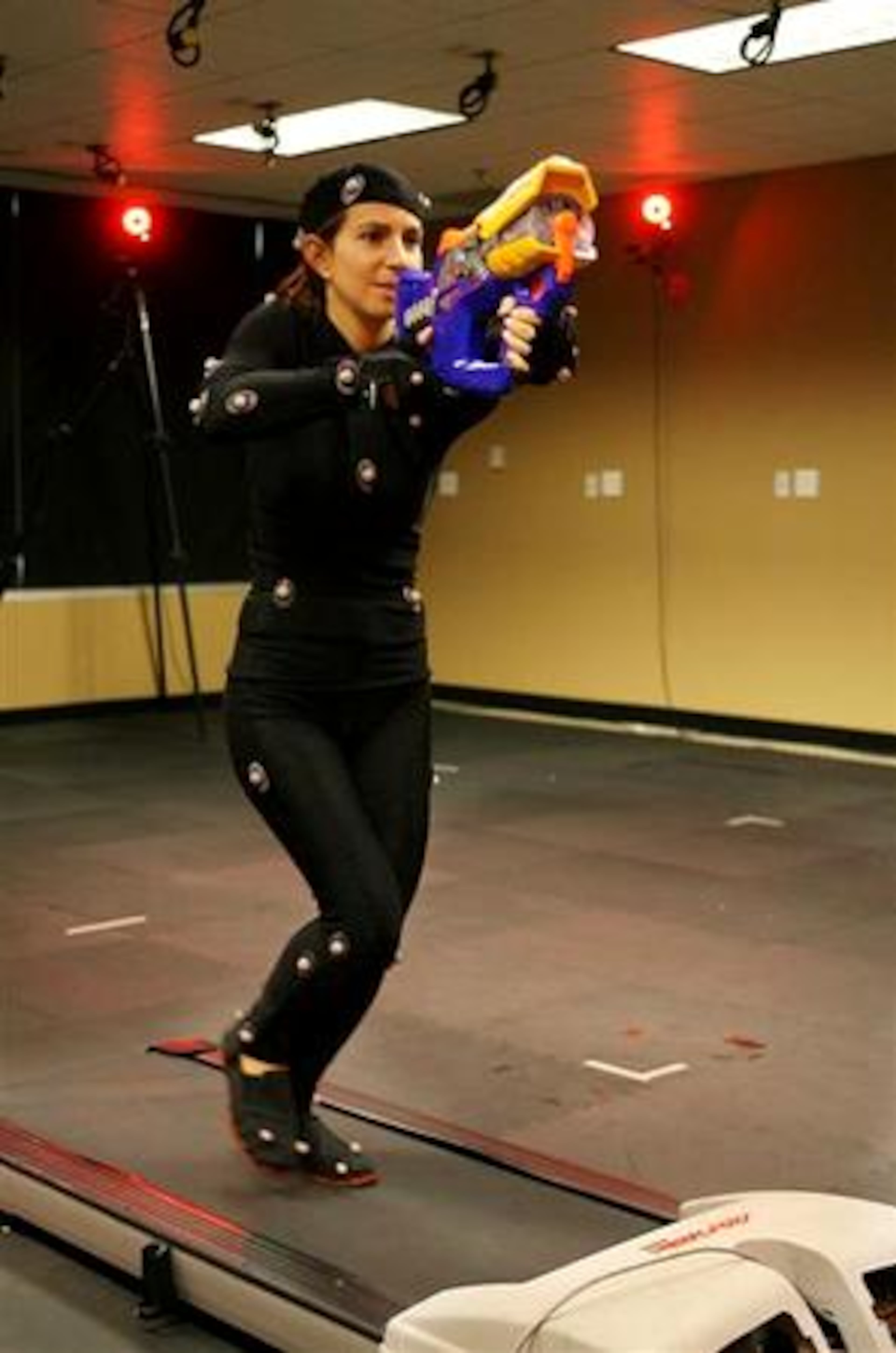 Michal Adam runs on a treadmill while aiming a weapon during a motion capture session at Hi-Rez Studios in Alpharetta. Multiple cameras around the room capture the "markers" on Adam to create a three dimensional image.