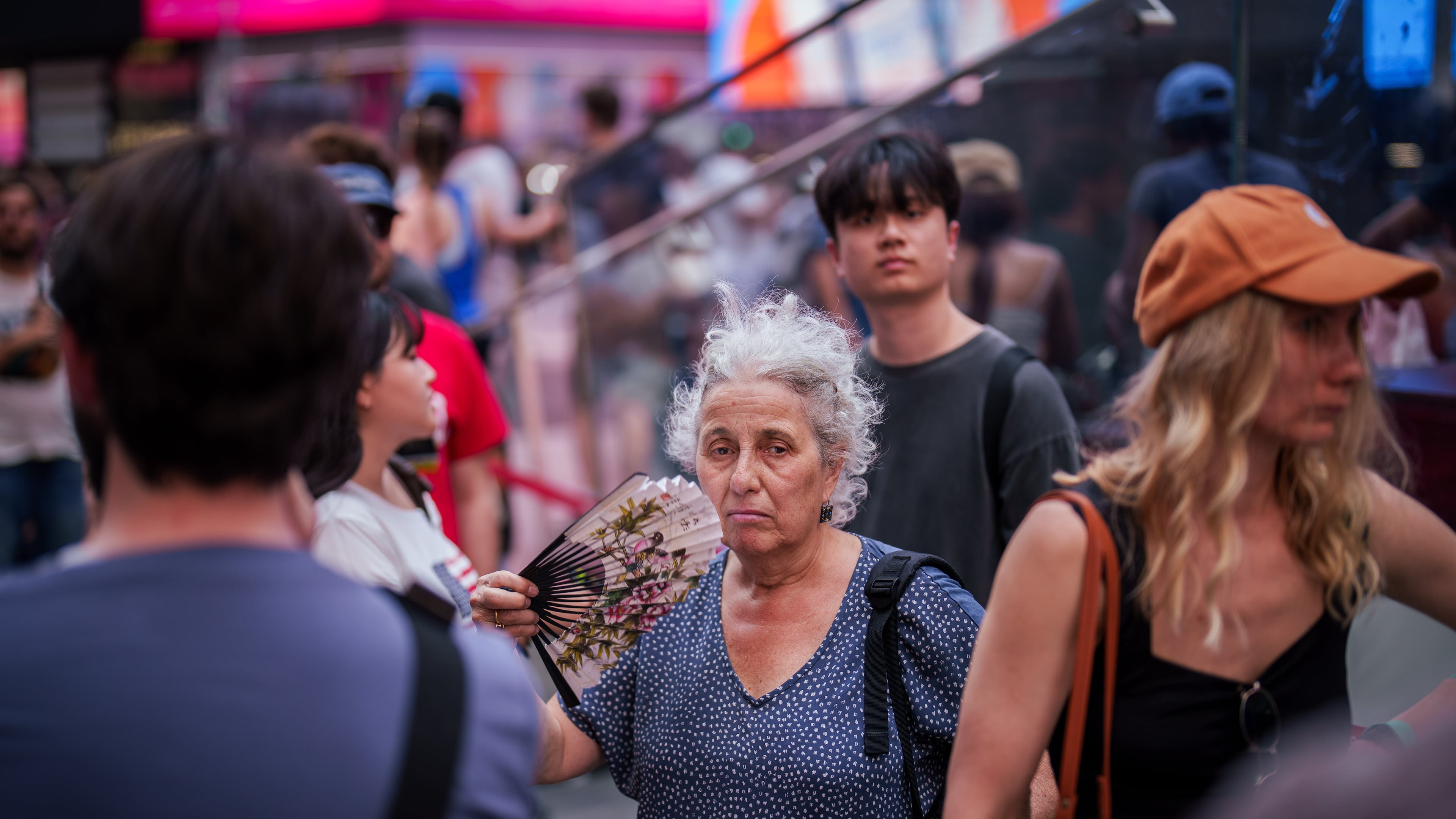 FILE - A person uses a fan as they wait in line to purchase Broadway tickets in Times Square, during a heat advisory in New York, May 19, 2026. (AP Photo/Adam Gray, File)