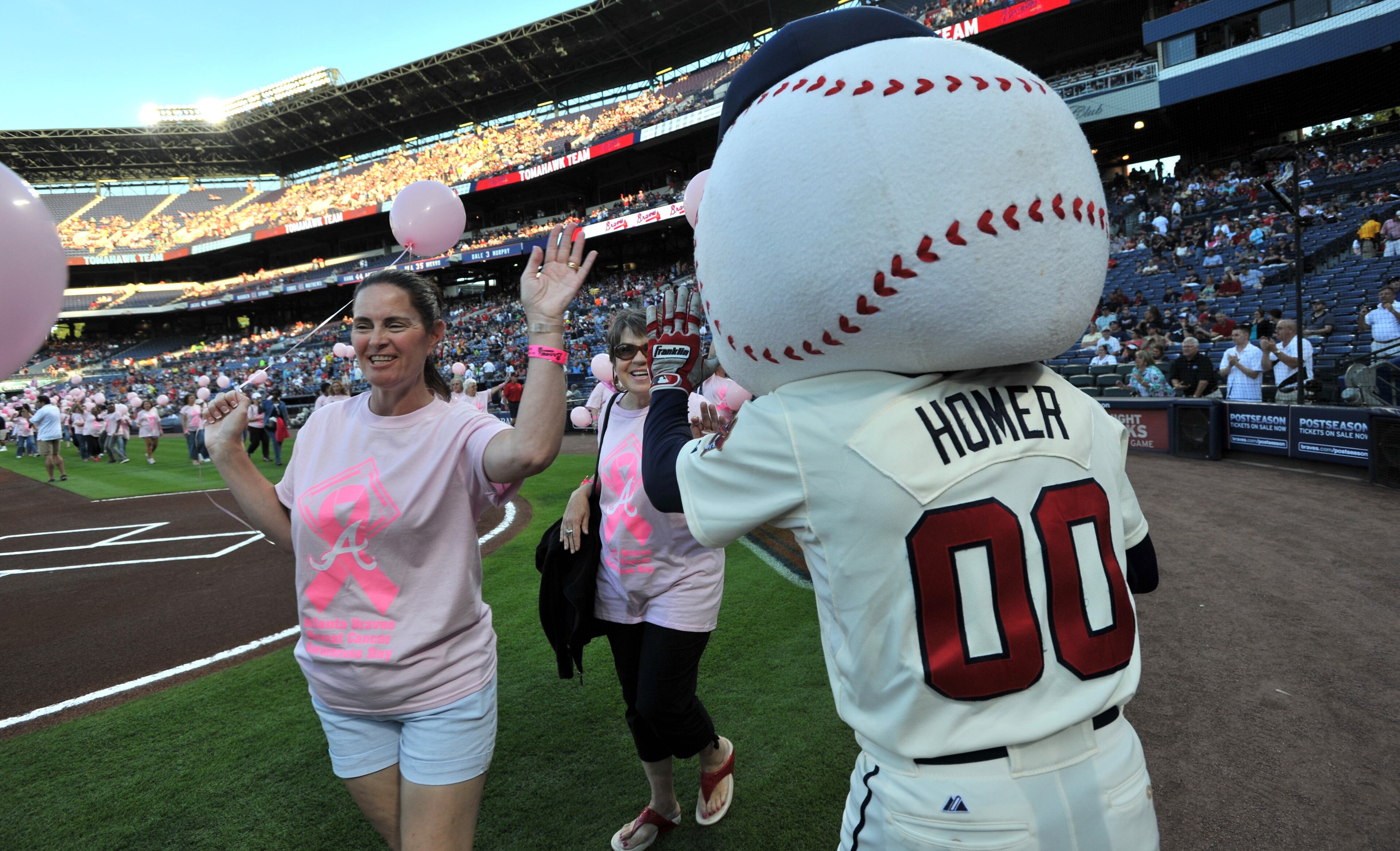 Atlanta Braves Homer high fives survivors during "A Walk in the Park" a Pre-Game On-Field Ceremony before Atlanta Braves game against the San Diego Padres at Turner Field in Atlanta on Saturday, September 14, 2013. This season, the Atlanta Braves, WellStar Health System, Kroger and the American Cancer Society's Making Strides Against Breast Cancer team up for the 7th Annual Braves Breast Cancer Awareness Day on Saturday, September 14, 2013 at 7:10 pm. The day-long celebration of survivorship honors those who have courageously battled breast cancer, and raised awareness and funds to support research, education and advocacy for cancer patients and their families throughout metro Atlanta.