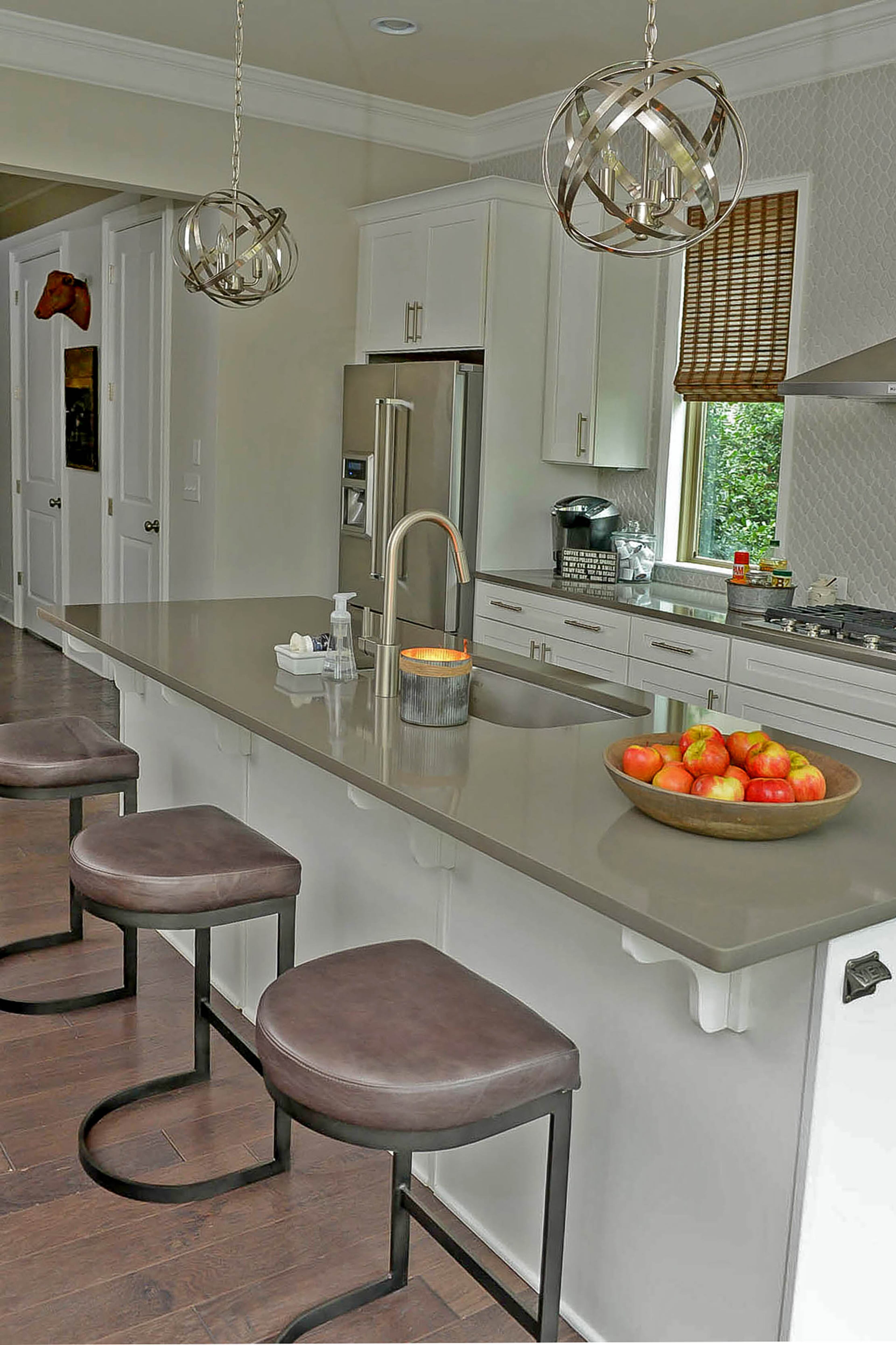 Cambria quartz countertops, modern hardware and white cabinetry give a clean and streamlined style in the kitchen. The plumbing fixtures are Moen.