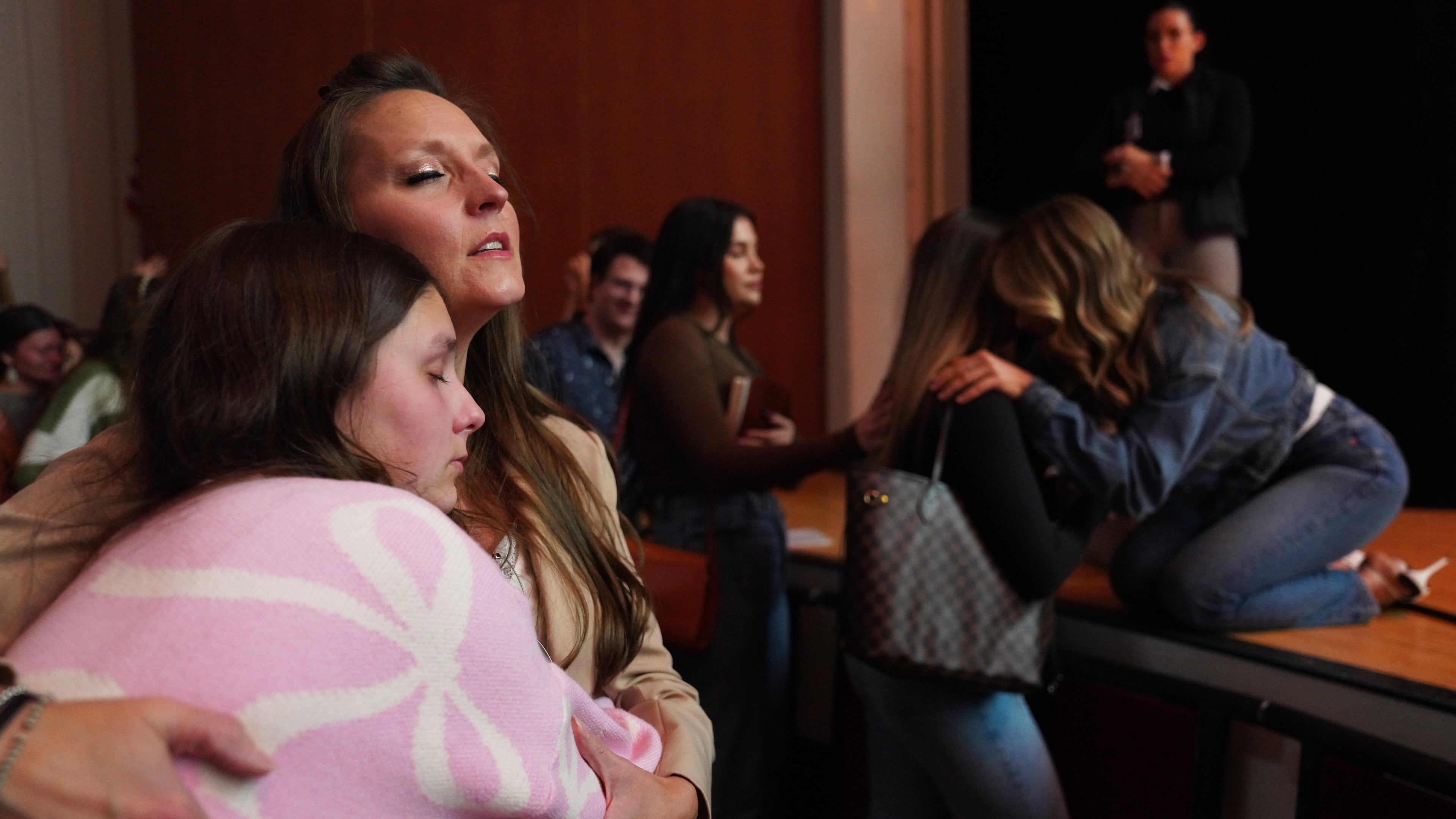Angela Halili, 29, right, cohost of the Christian podcast, "Girls Gone Bible," prays over a follower during their live show held at the Atlanta Symphony Hall, Friday, Nov. 14, 2025, in Atlanta. (AP Photo/Jessie Wardarski)