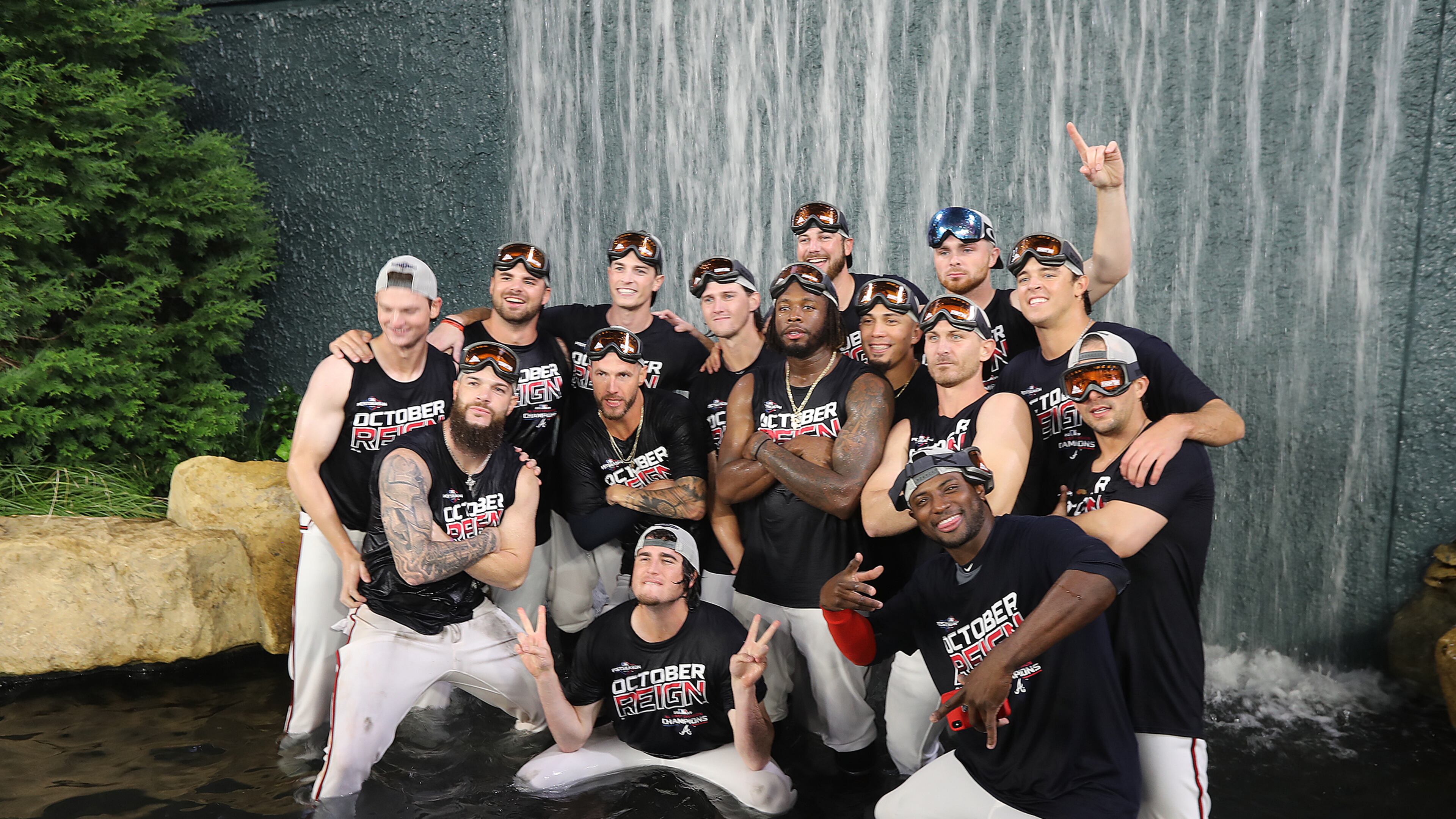Braves players climb into the outfield waterfall to celebrate clinching the National League East title. Curtis Compton/ccompton@ajc.com