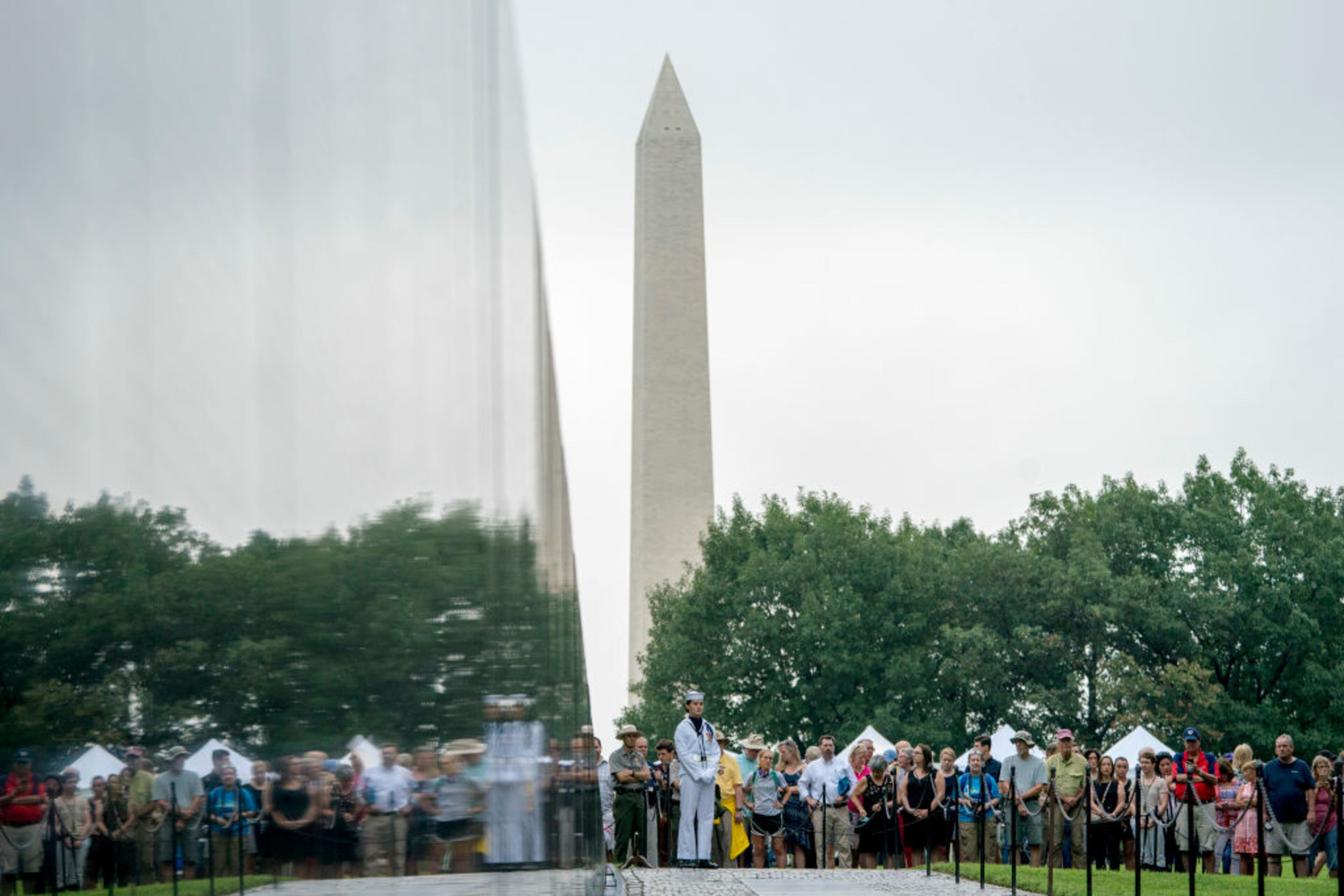 WASHINGTON, DC - AUGUST 31: A crowd gathers before Cindy McCain, wife of, Sen. John McCain, R-Ariz., arrives to lay a wreath at the Vietnam Veterans Memorial in Washington, Saturday, Sept. 1, 2018, during a funeral procession to carry the casket of her husband from the U.S. Capitol to National Cathedral for a memorial service. McCain served as a Navy pilot during the Vietnam War and was a prisoner of war for more than five years. (AP Photo/Andrew Harnik, Pool)