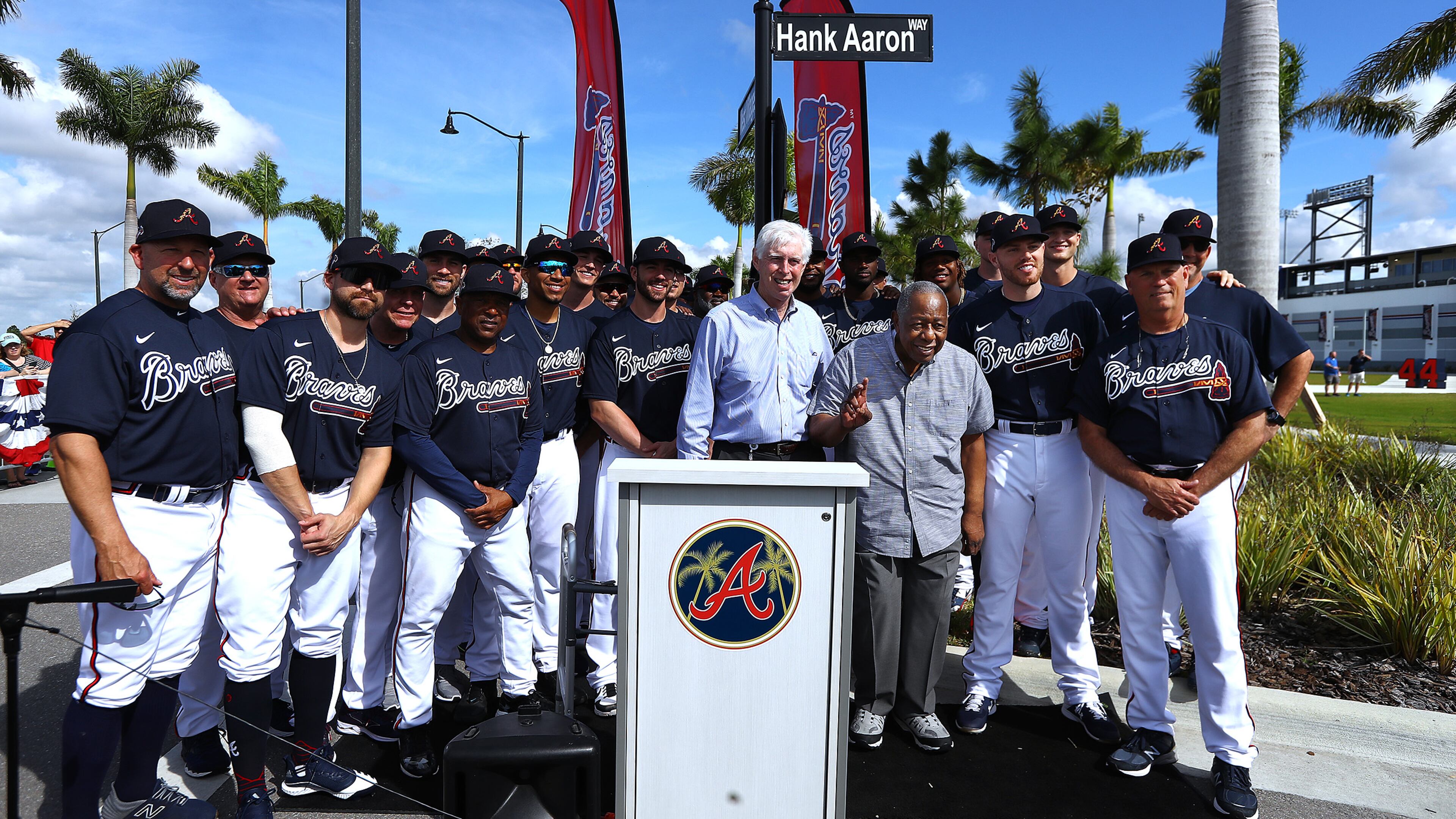 Braves Chairman Terry McGuirk and the Braves team gather with Hall of Famer Hank Aaron who waves to the crowd as the team honors the Hall of Famer by naming a street outside of CoolToday Park "Hank Aaron Way" on Tuesday, Feb. 18, 2020, in North Port, Fla.