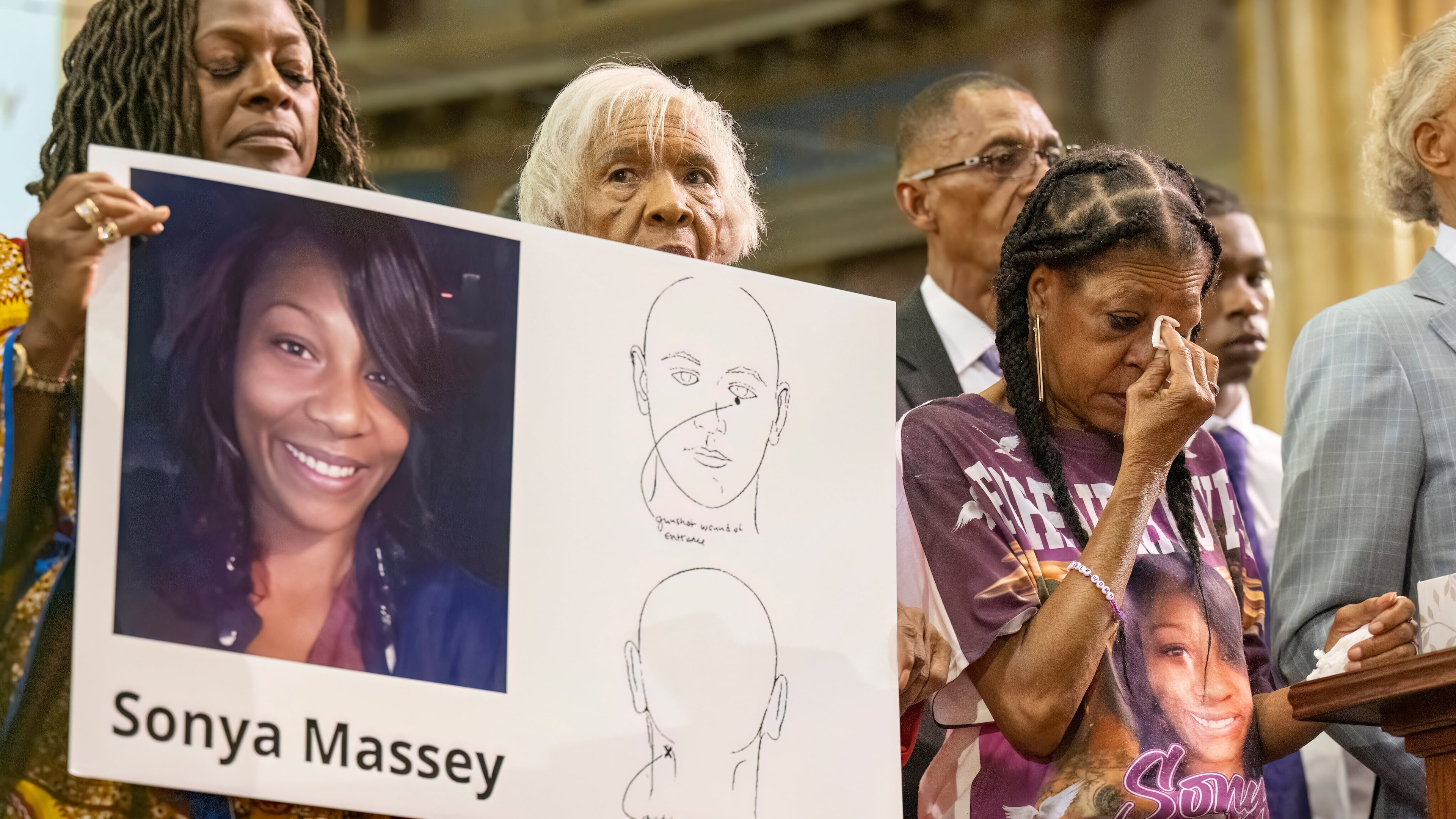 FILE - Donna Massey, center right, wipes tears from her face as she listens to Rev. Al Sharpton, right, speak during a press conference over the shooting death of her daughter, Sonya, who was killed by Illinois sheriff's deputy Sean Grayson, at New Mount Pilgrim Church in Chicago, July 30, 2024. (Tyler Pasciak LaRiviere/Chicago Sun-Times via AP, File)
