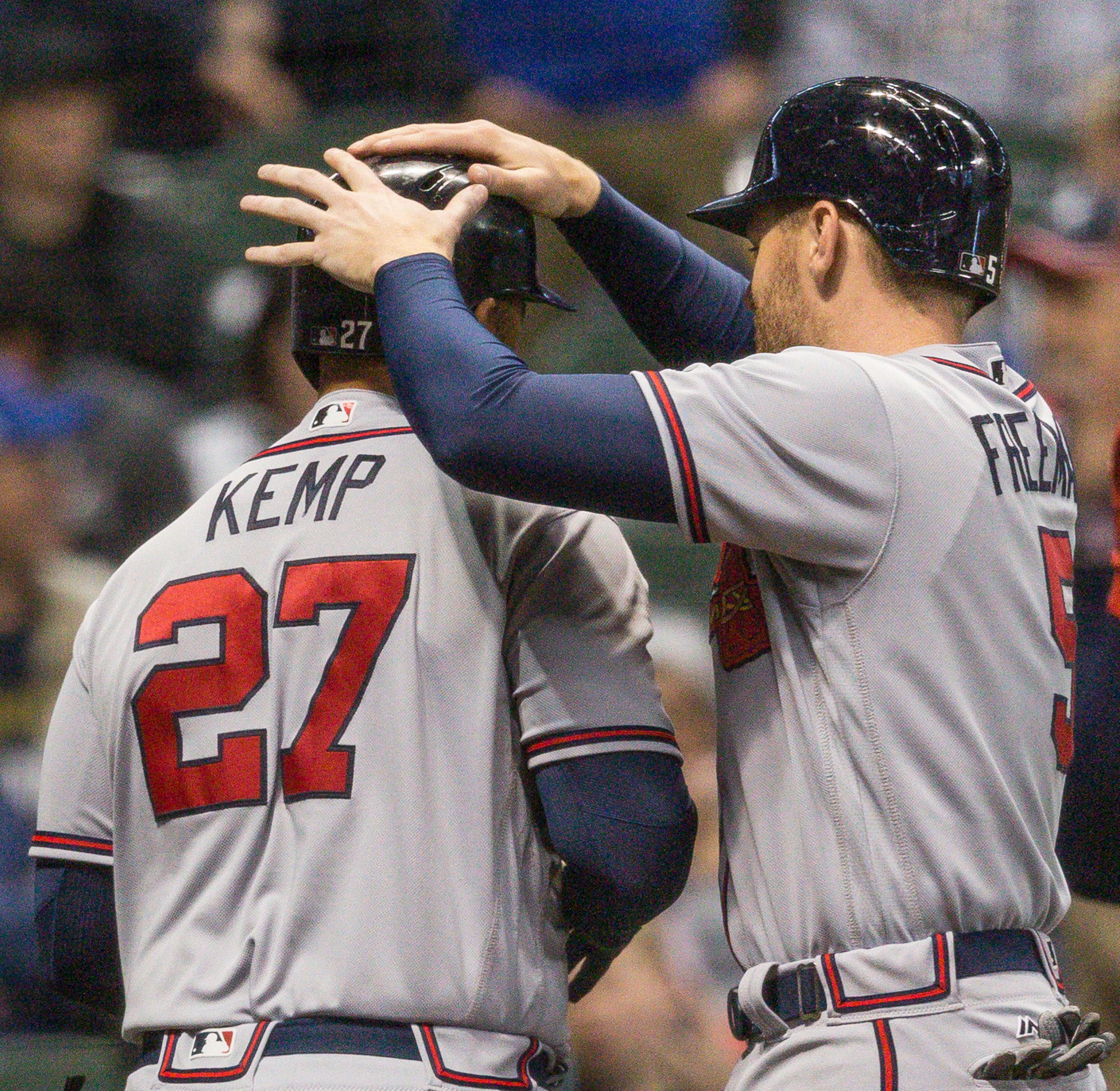 Atlanta Braves' Matt Kemp has his helmet tapped by teammate Freddie Freeman after hitting his third home run of a baseball game against the Milwaukee Brewers during the eighth inning Saturday, April 29, 2017, in Milwaukee. (AP Photo/Tom Lynn)