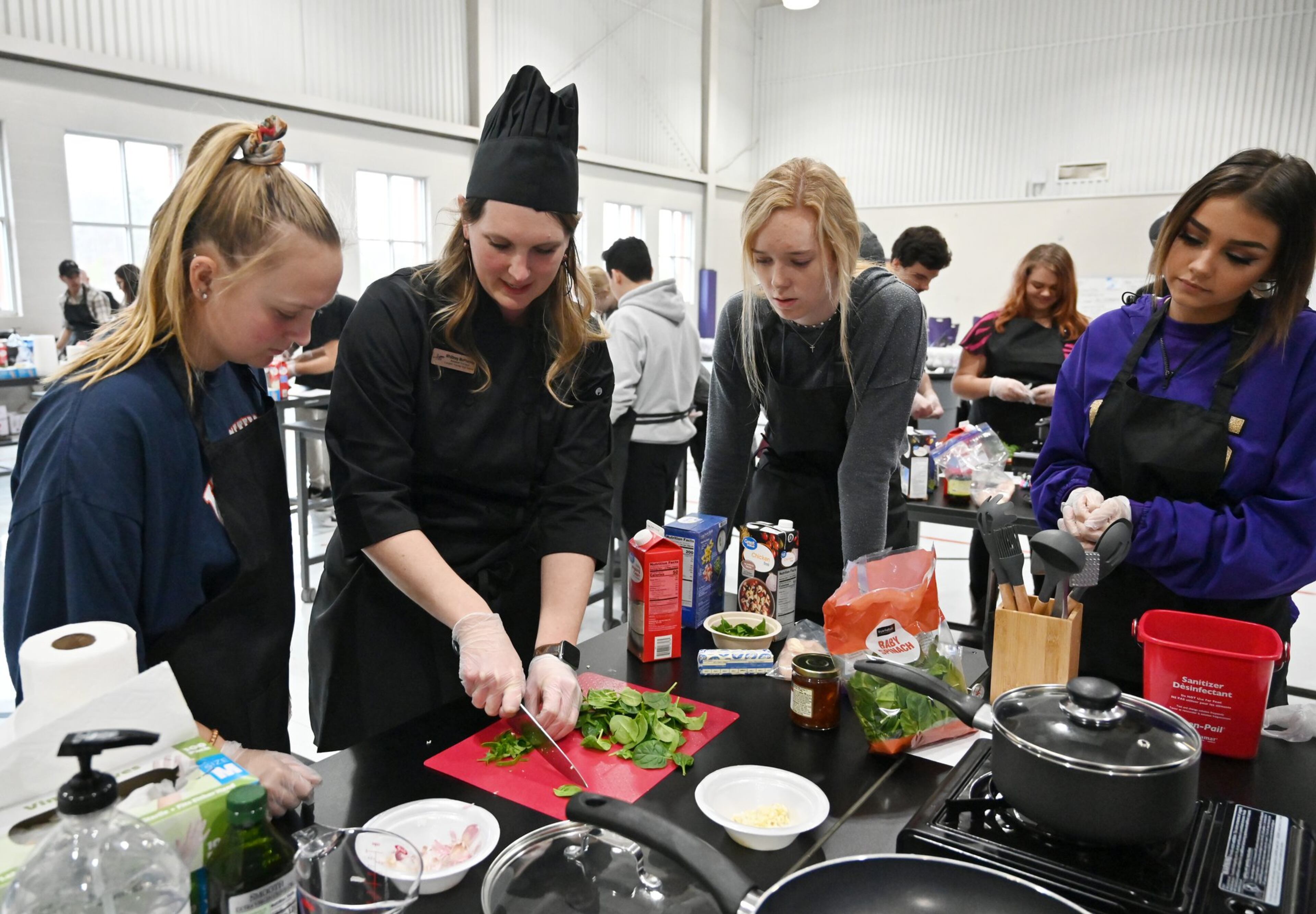 Assistant Principal Whittney McPherson (second from left) demonstrates cooking skills during the second annual Senior Adulting Day at Lumpkin County High School in Dahlonega on Friday, Jan. 24, 2020.
