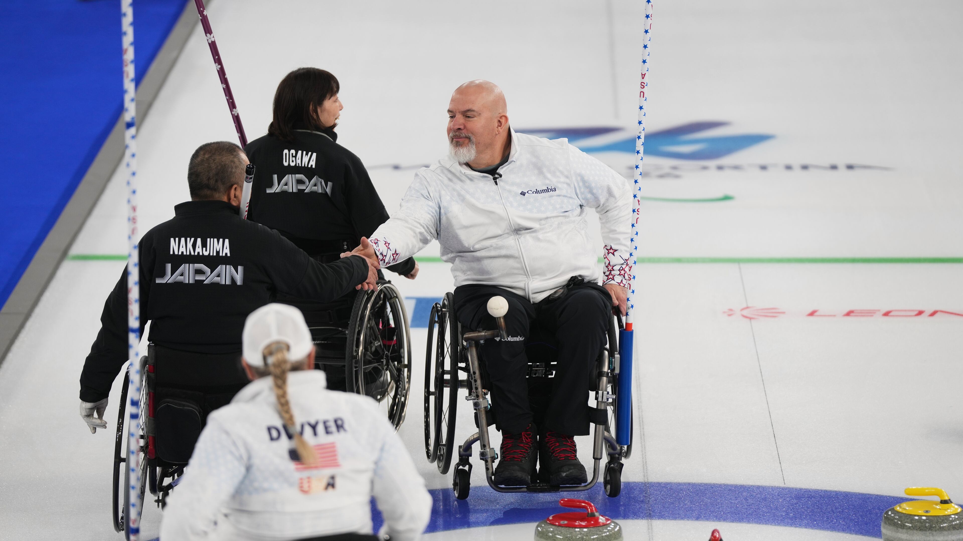 Steve Emt, right, and Laura Dwyer, of the United States, and Yoji Nakajima, left, and Aki Ogawa, of Japan, greet each other after their wheelchair curling mixed doubles round robin session at the 2026 Winter Paralympics, in Cortina d'Ampezzo, Italy, Thursday, March 5, 2026. (AP Photo/Evgeniy Maloletka)