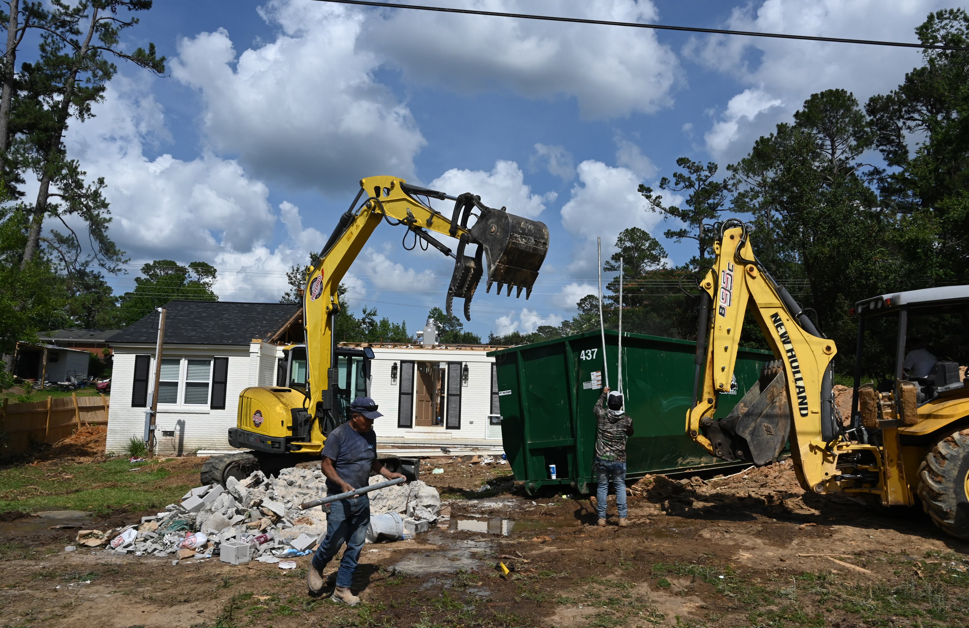 A construction crew works on rebuilding a home devastated by Hurricane Helene in the Old Wood Valley neighborhood of Valdosta on Tuesday. (Hyosub Shin/AJC)