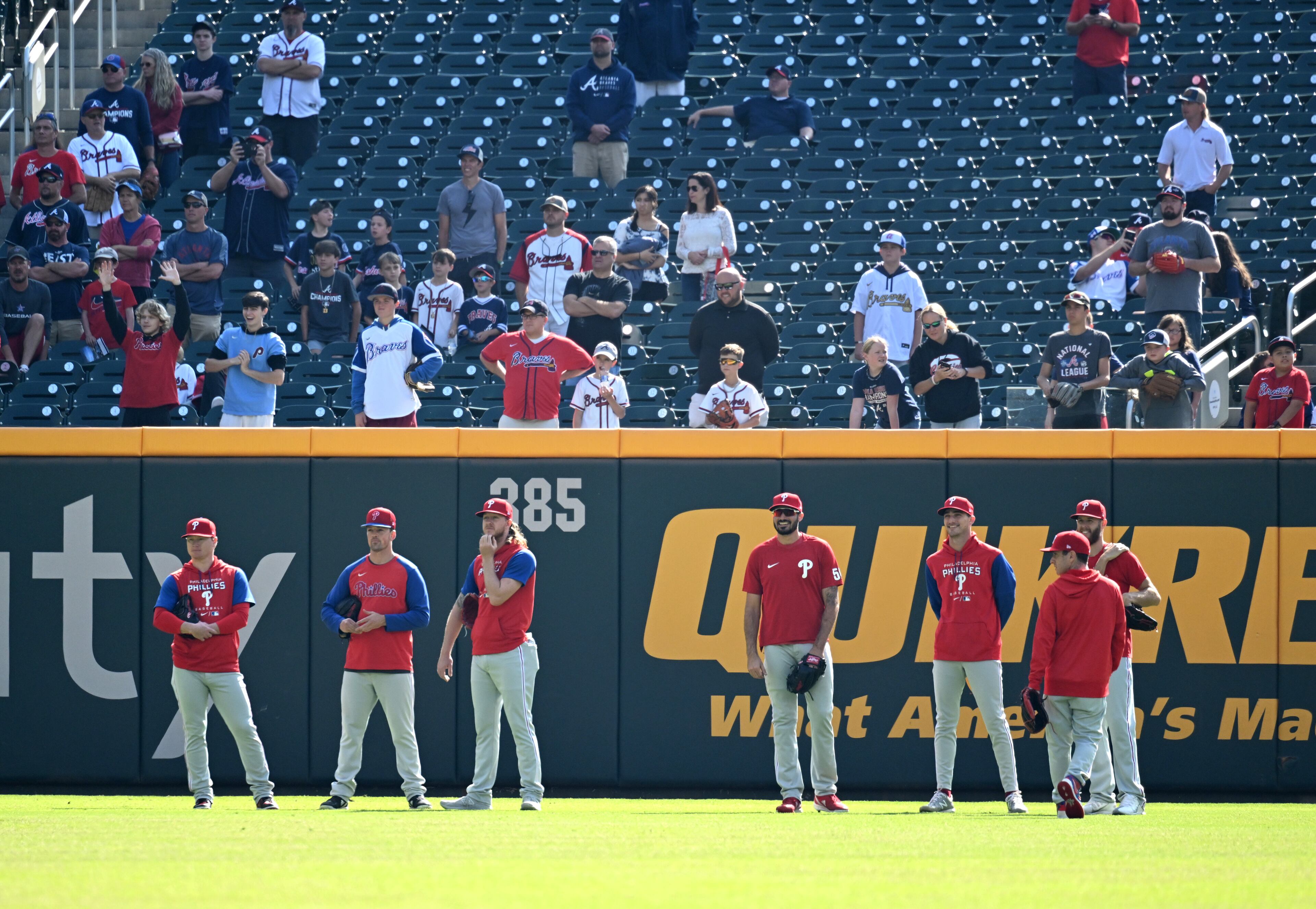 Phillies players stand in the outfield during their workout before Tuesday's playoff game at Truist Park.