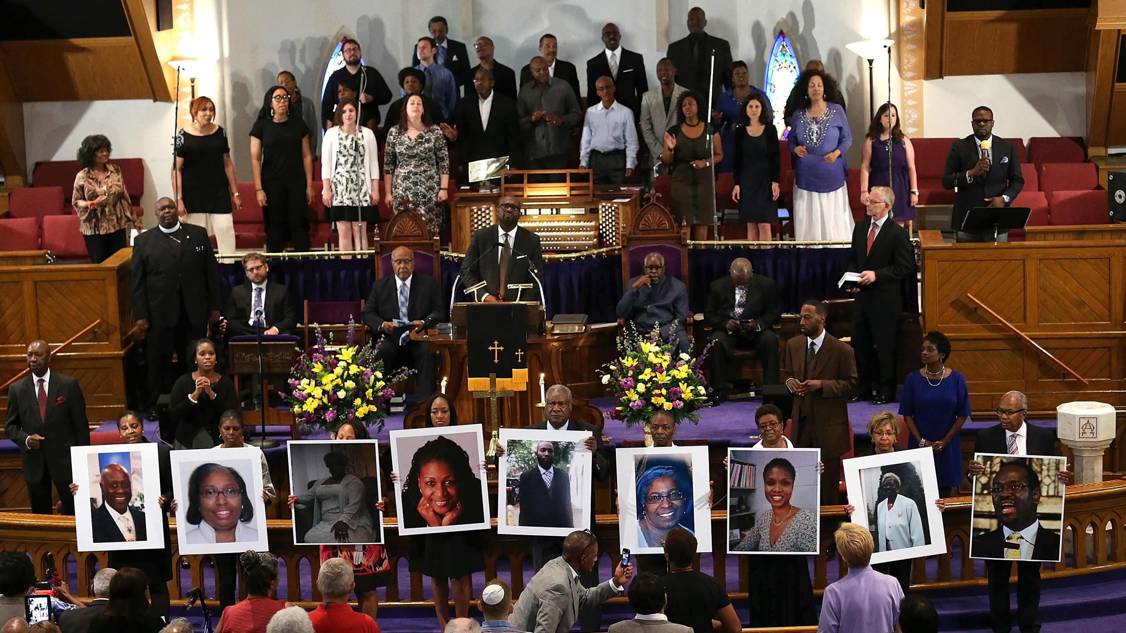 Photographs of the nine victims killed at the Emanuel AME Church in Charleston, South Carolina, are held up by congregants during a prayer vigil at the Metropolitan AME Church on June 19, 2015, in Washington, DC. (Win McNamee/Getty Images)