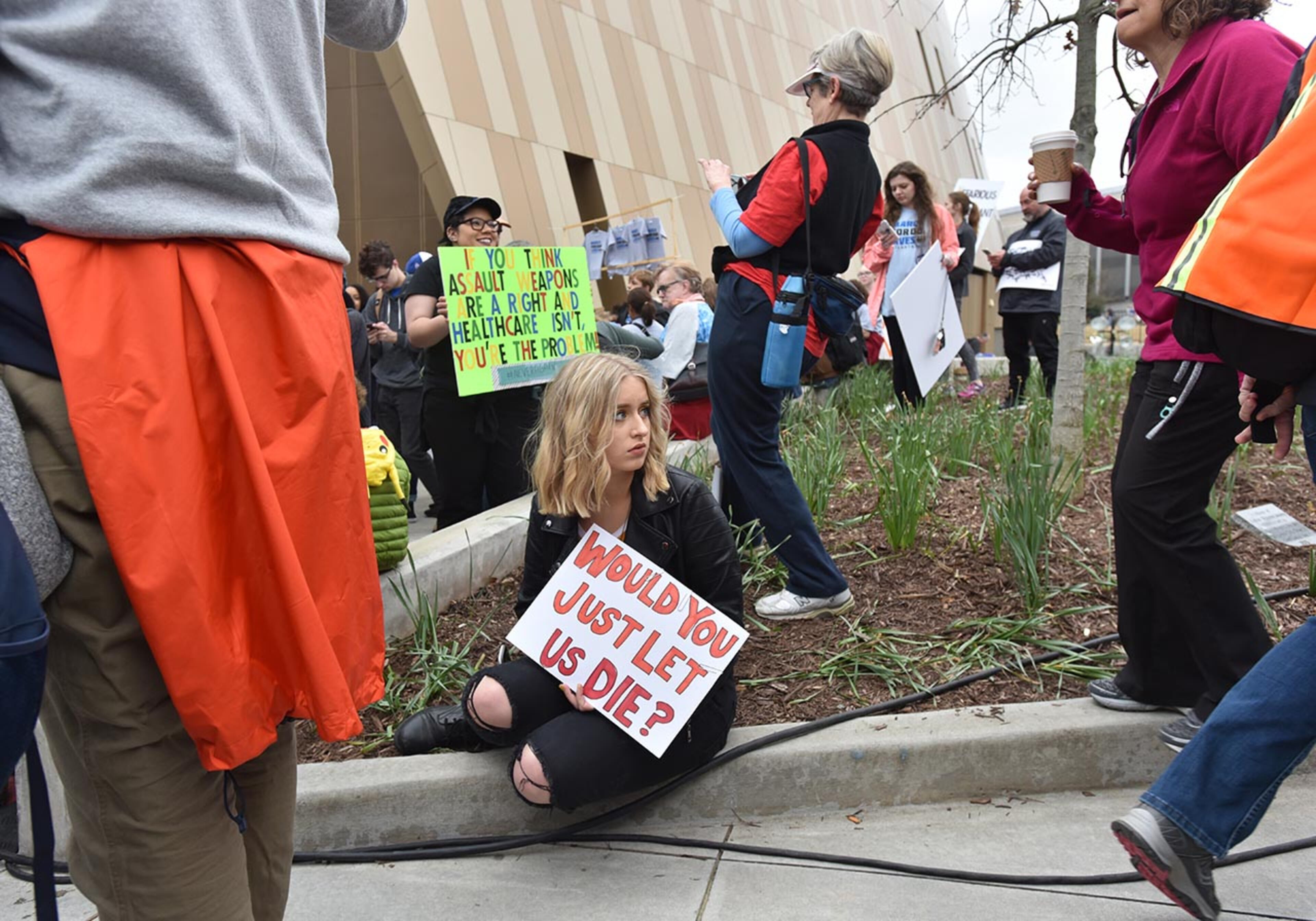 March 24, 2018 Atlanta - A protester holds a sign as she sits out the Center for Civil and Human Rights before walking to Liberty Plaza on Saturday, March 24, 2018. Atlanta police estimated the crowd at near 30,000 for todayâÃôs March for Our Lives. People of all ages were drawn to one of the nationwide demonstrations in a movement begun by student survivors of last monthâÃôs mass killing in a Parkland, Fla., school. Some of those Florida students were among the speakers in Atlanta. HYOSUB SHIN / HSHIN@AJC.COM