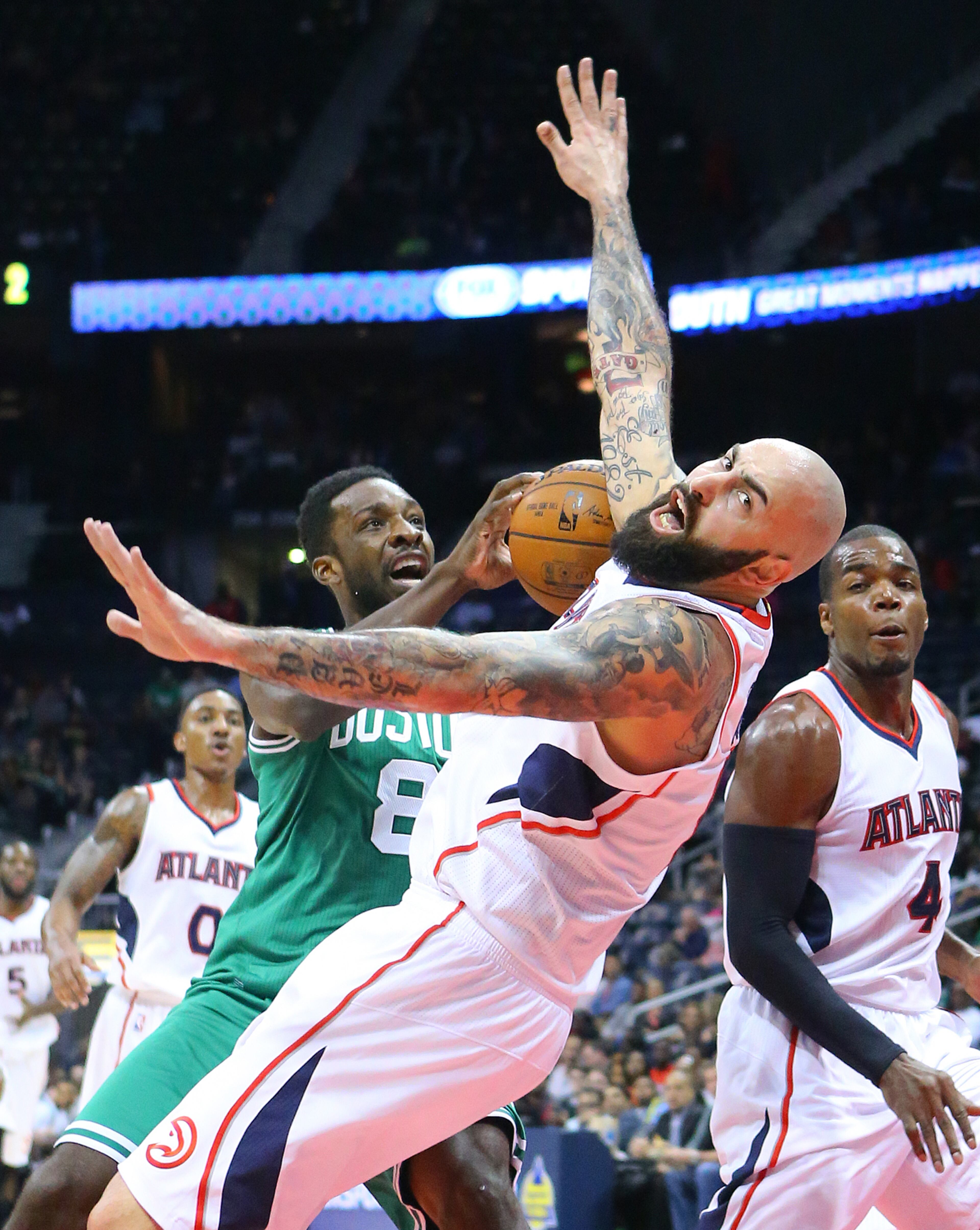 Celtics forward Jeff Green knocks Hawks forward Pero Antic to the hardwood on a collision while trying to drive to the basket during the first half in an NBA basketball game on Tuesday, Dec. 2, 2014, in Atlanta. CURTIS COMPTON / CCOMPTON@AJC.COM