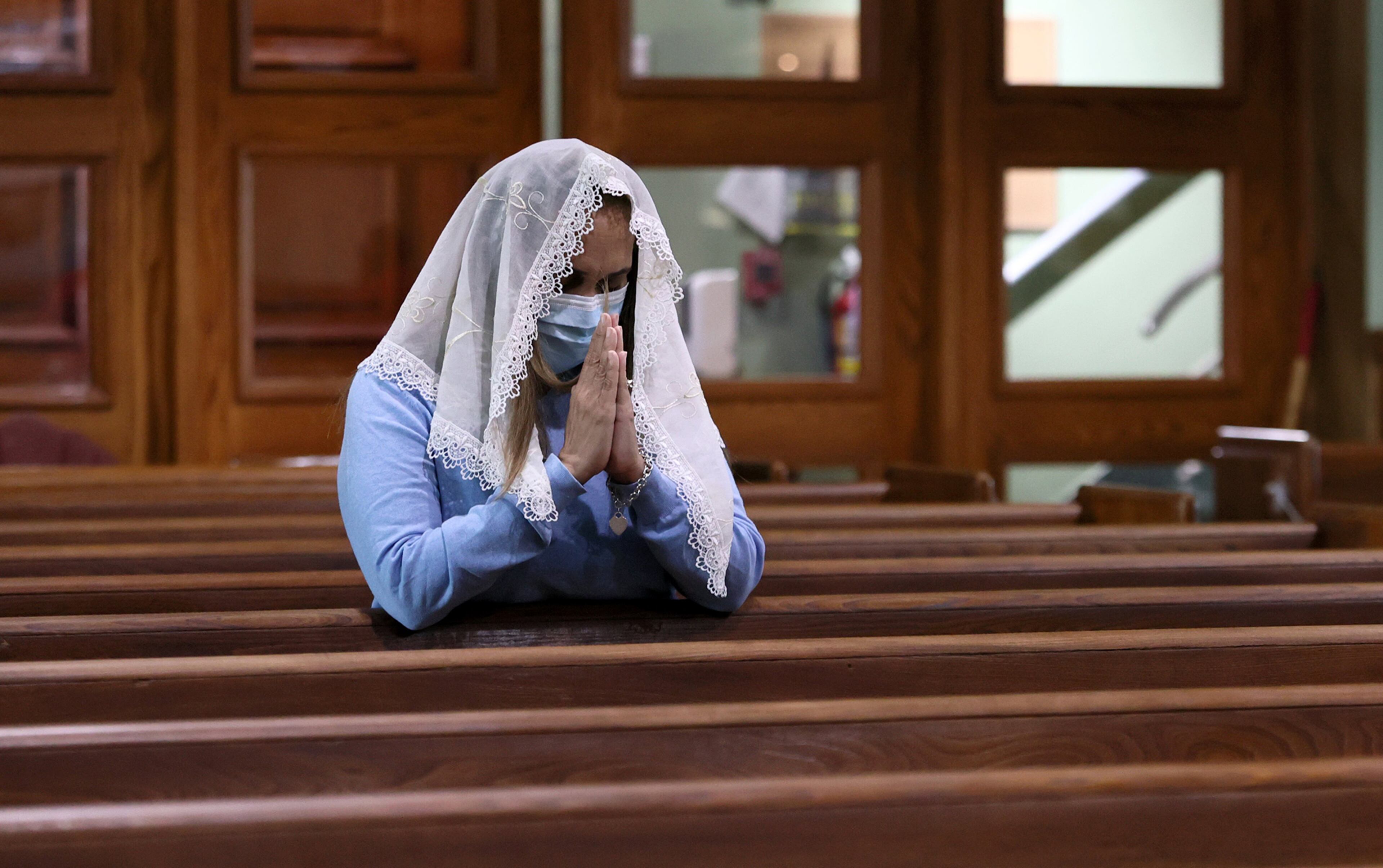 A churchgoer prays during Sunday mass at St. Josephís catholic church in Miami Beach on June 27, 2021. The apartment building partially collapsed on Thursday, June 24. (David Santiago/Miami Herald/TNS)
