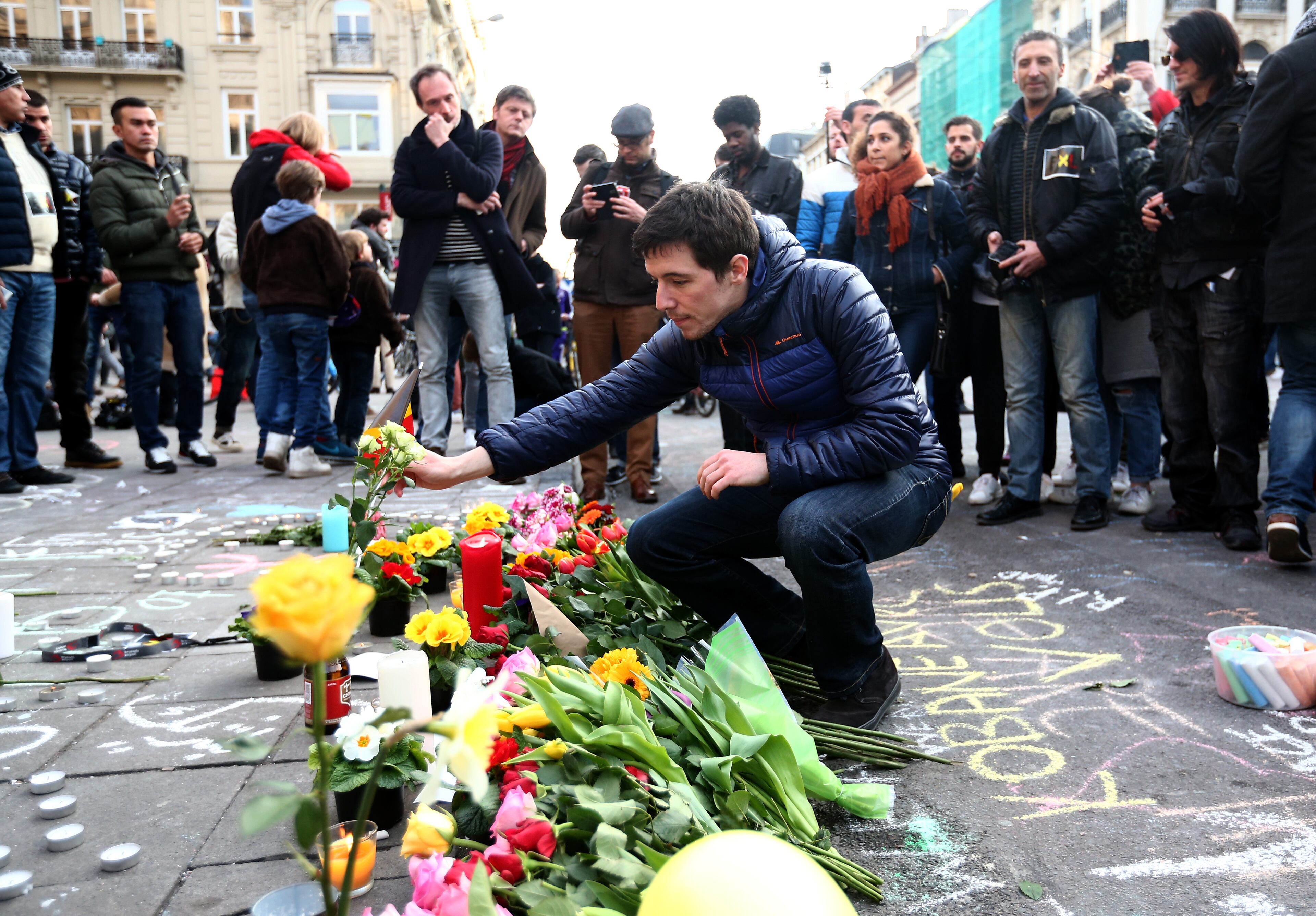BRUSSELS, BELGIUM - MARCH 22: People gather to leave tributes at the Place de la Bourse following today's attacks on March 22, 2016 in Brussels, Belgium. At least 31 people are thought to have been killed after Brussels airport and a Metro station were targeted by explosions. The attacks come just days after a key suspect in the Paris attacks, Salah Abdeslam, was captured in Brussels. (Photo by Carl Court/Getty Images)