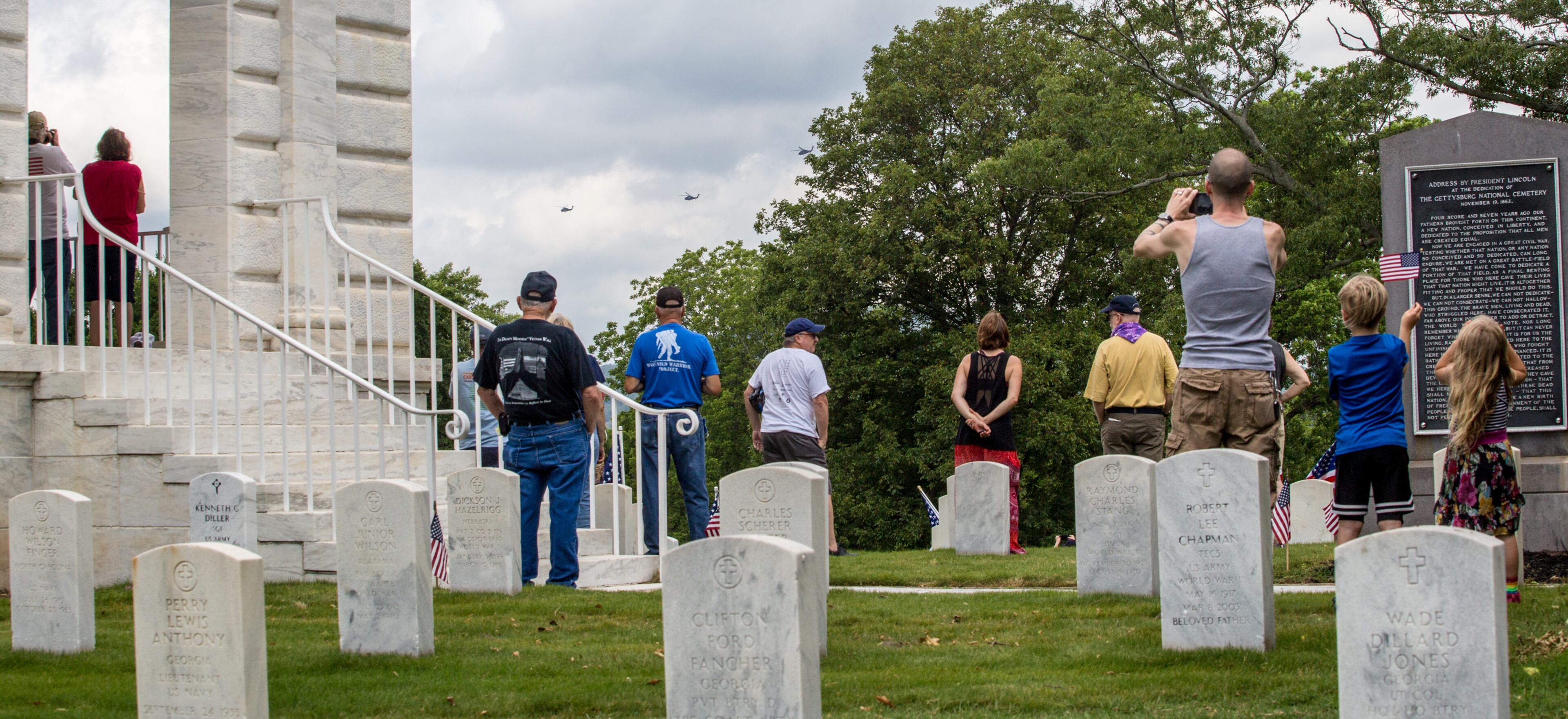 The Marietta National Cemetery did not hold official ceremonies this year, however, small groups gathered to watch the four Blackhawk helicopter flyover on Memorial Day, Monday, May 25, 2020. (Jenni Girtman for The Atlanta Journal Constitution)