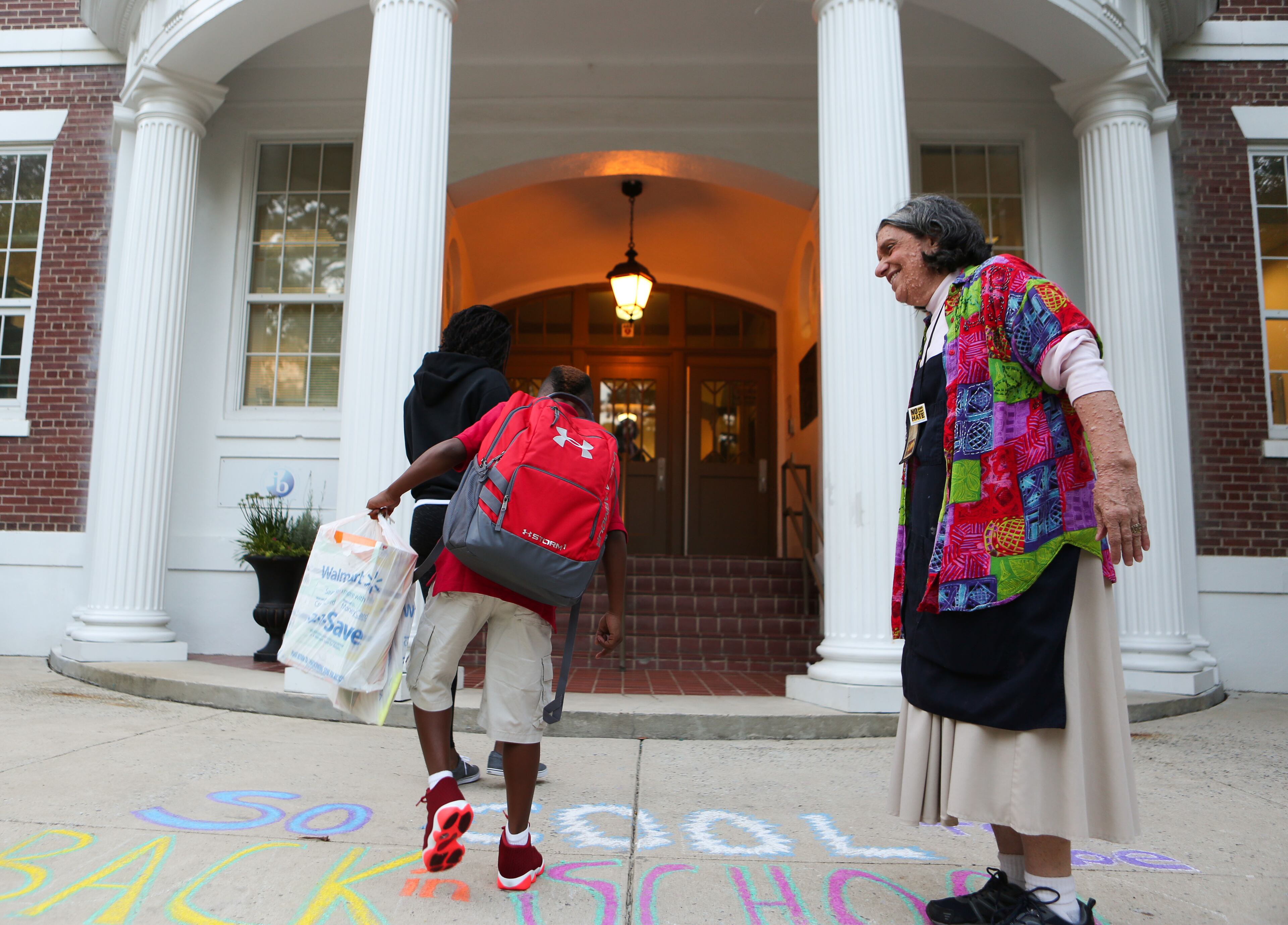 Cissy Cohen, an art teacher at Garden Hills Elementary School, greets students on their first day of school as they walk through the front doors of Garden Hills Elementary School on Wednesday, August 3, 2016. Students at Garden Hills Elementary School went back to school on Wednesday morning, where Atlanta Public Schools Superintendent Meria Carstarphen had breakfast with the students before they reported to their classrooms. READ MORE: Back to school for Atlanta students