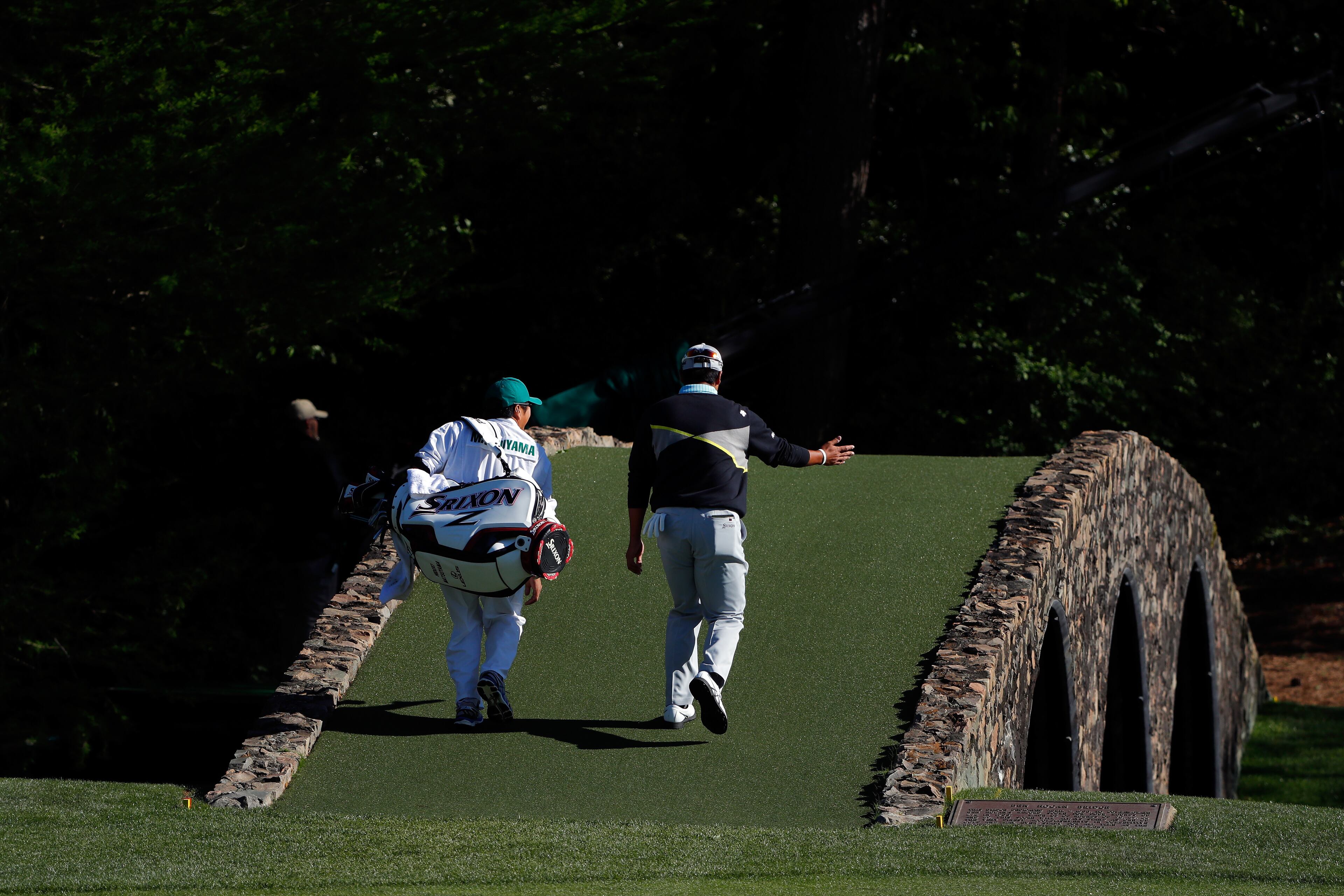AUGUSTA, GEORGIA - APRIL 09: Hideki Matsuyama of Japan and caddie Daisuke Shindo walk across the Hogan bridge to the 12th green during the third round of the 2016 Masters Tournament at Augusta National Golf Club on April 9, 2016 in Augusta, Georgia. (Photo by Kevin C. Cox/Getty Images)