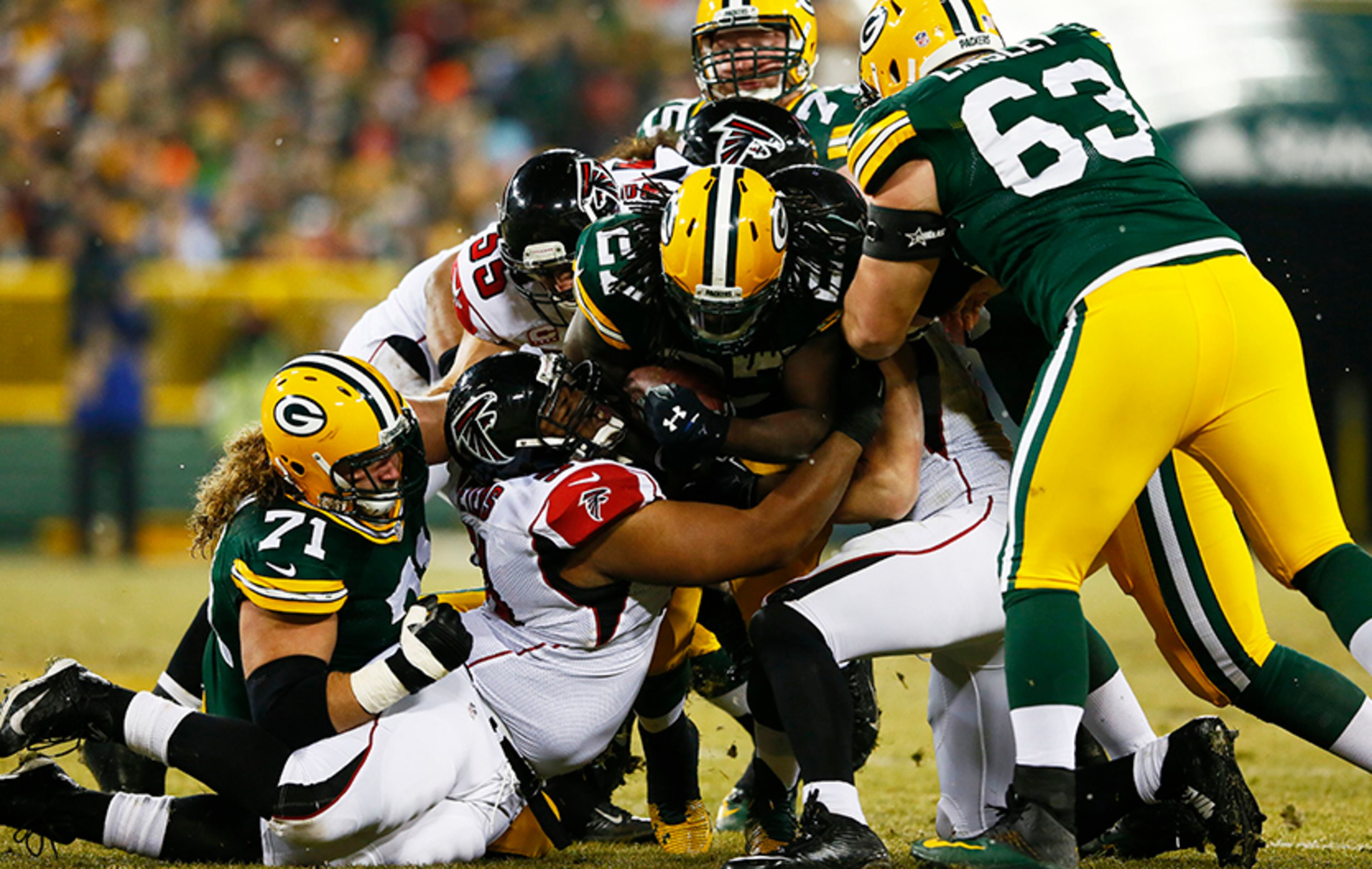 Packers running back Eddie Lacy is tackled by the Falcons' Corey Peters (91), Paul Worrilow (55) and Kroy Biermann (71) Monday, Dec. 8, 2014, in Green Bay,Wis.