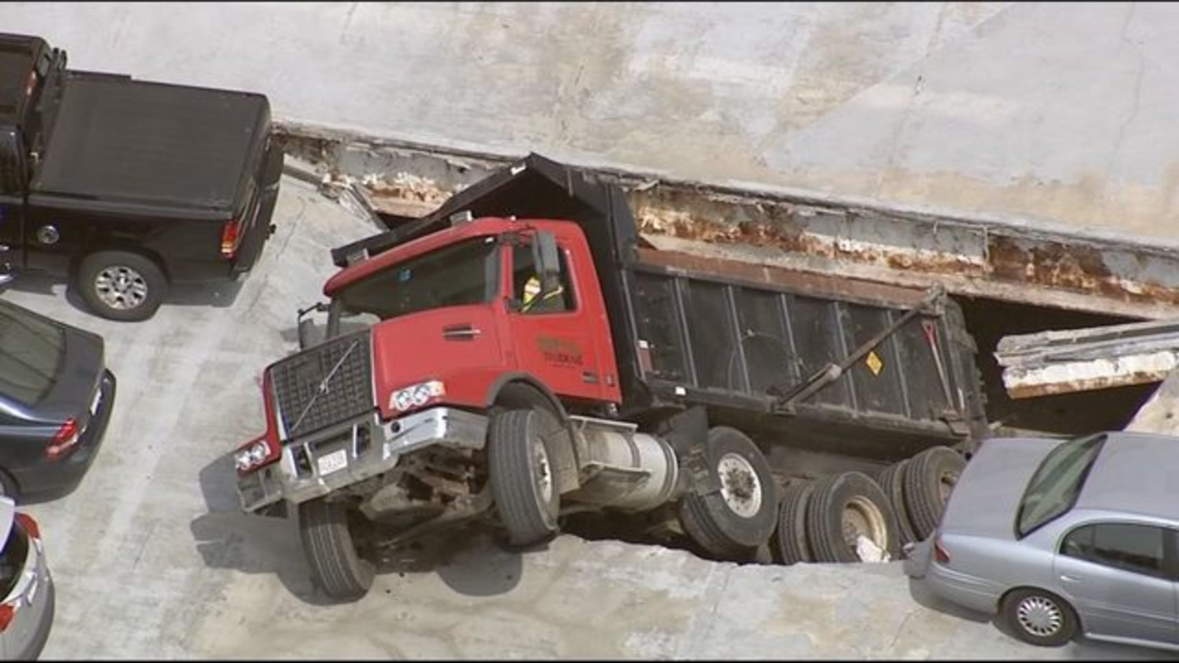 A dump truck has partially fallen through the roof deck of a parking garage in Massachusetts.