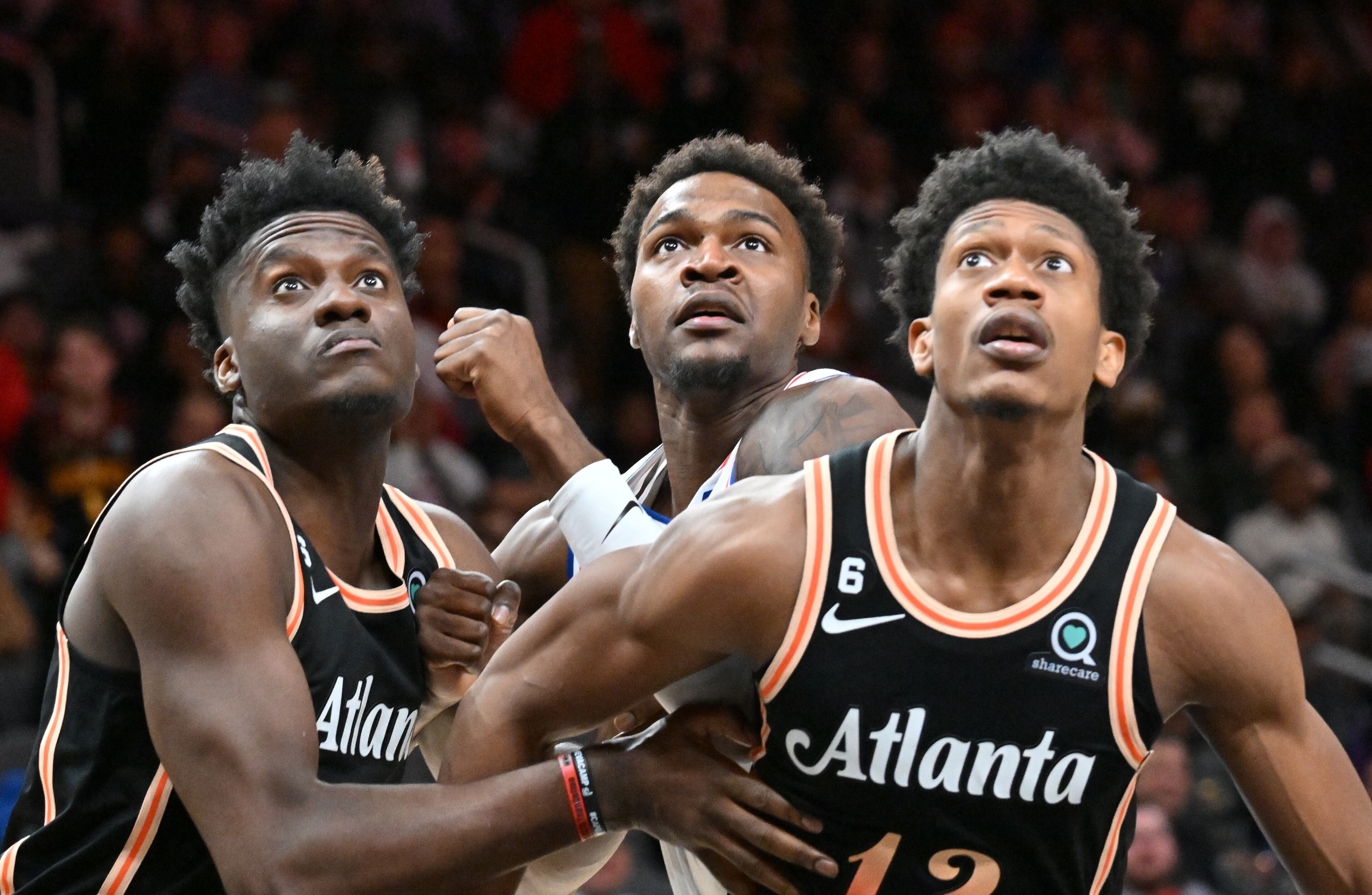 Hawks Onyeka Okongwu (left) and De'Andre Hunter (right) fight for rebound position with Philadelphia 76ers' Paul Reed (center). (Hyosub Shin / Hyosub.Shin@ajc.com)