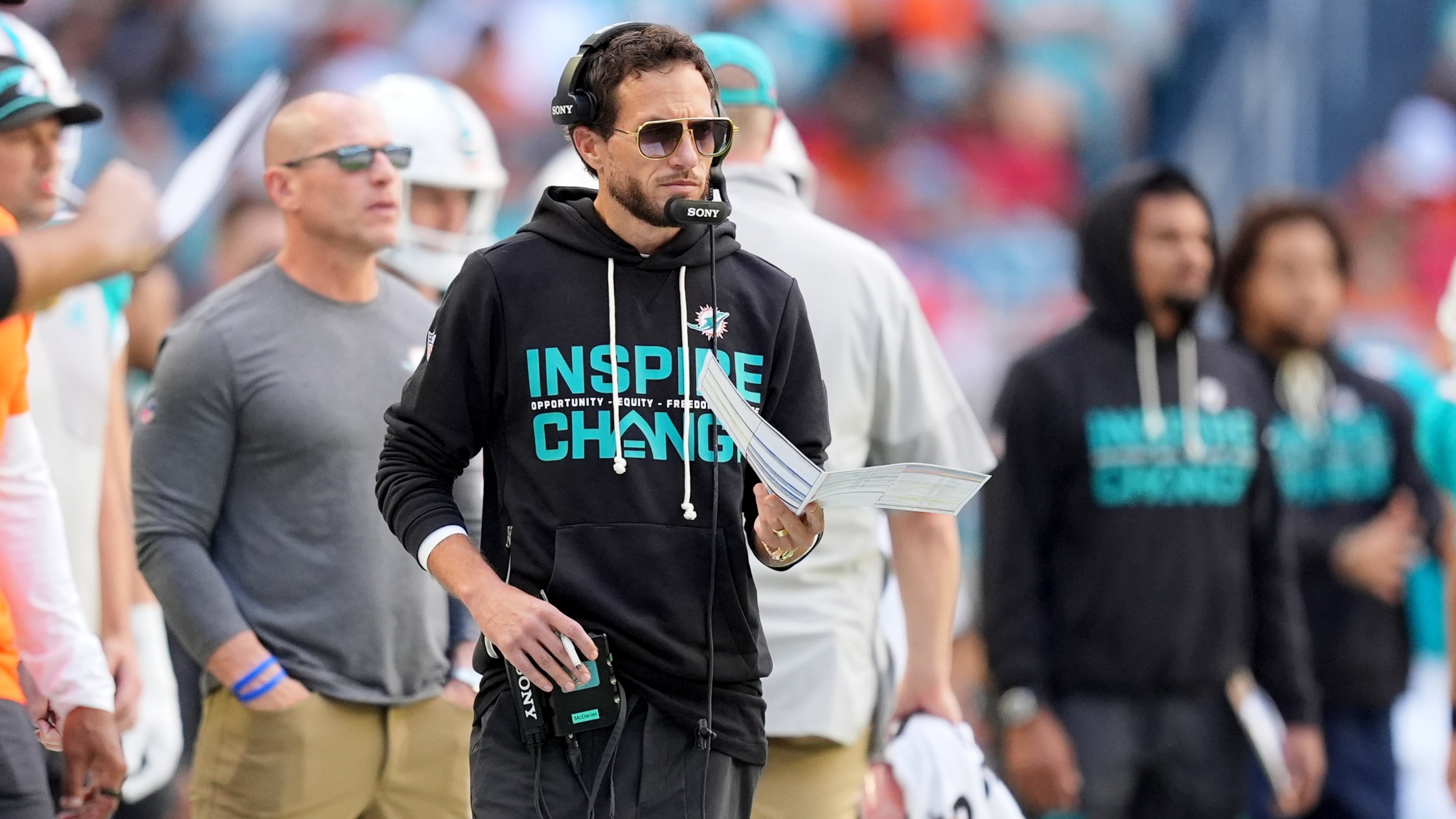 Miami Dolphins head coach Mike McDaniel, center, looks on during the first half of an NFL football game against the Tampa Bay Buccaneers, Sunday, Dec. 28, 2025, in Miami Gardens, Fla. (AP Photo/Rebecca Blackwell)