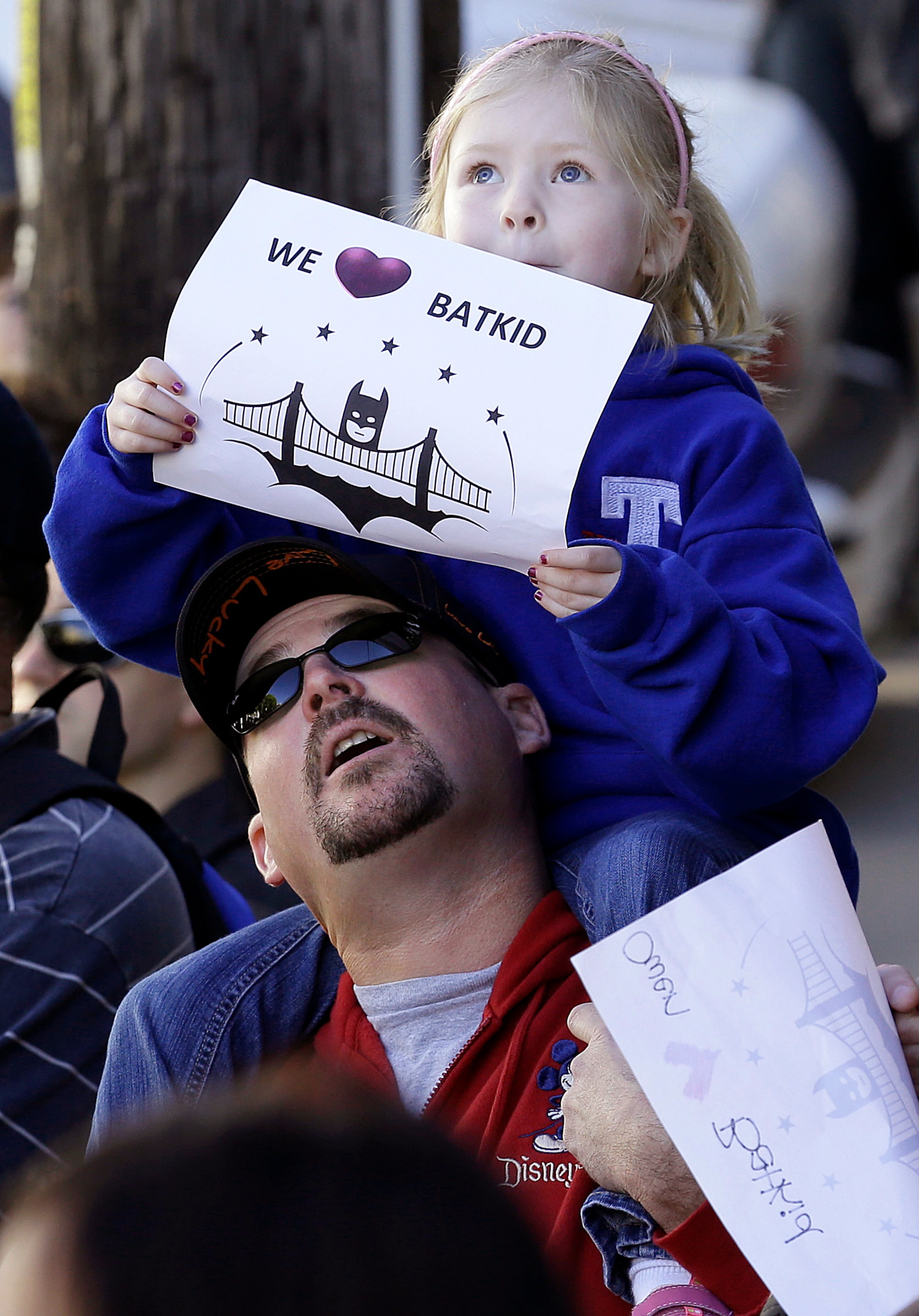 Daniel Fry holds up his daughter Kayla, 5, as they wait for Miles Scott, dressed as Batkid, in San Francisco, Friday, Nov. 15, 2013. San Francisco turned into Gotham City on Friday, as city officials helped fulfill Scott's wish to be "Batkid." Scott, a leukemia patient from Tulelake in far Northern California, was called into service on Friday morning by San Francisco Police Chief Greg Suhr to help fight crime, The Greater Bay Area Make-A-Wish Foundation says.