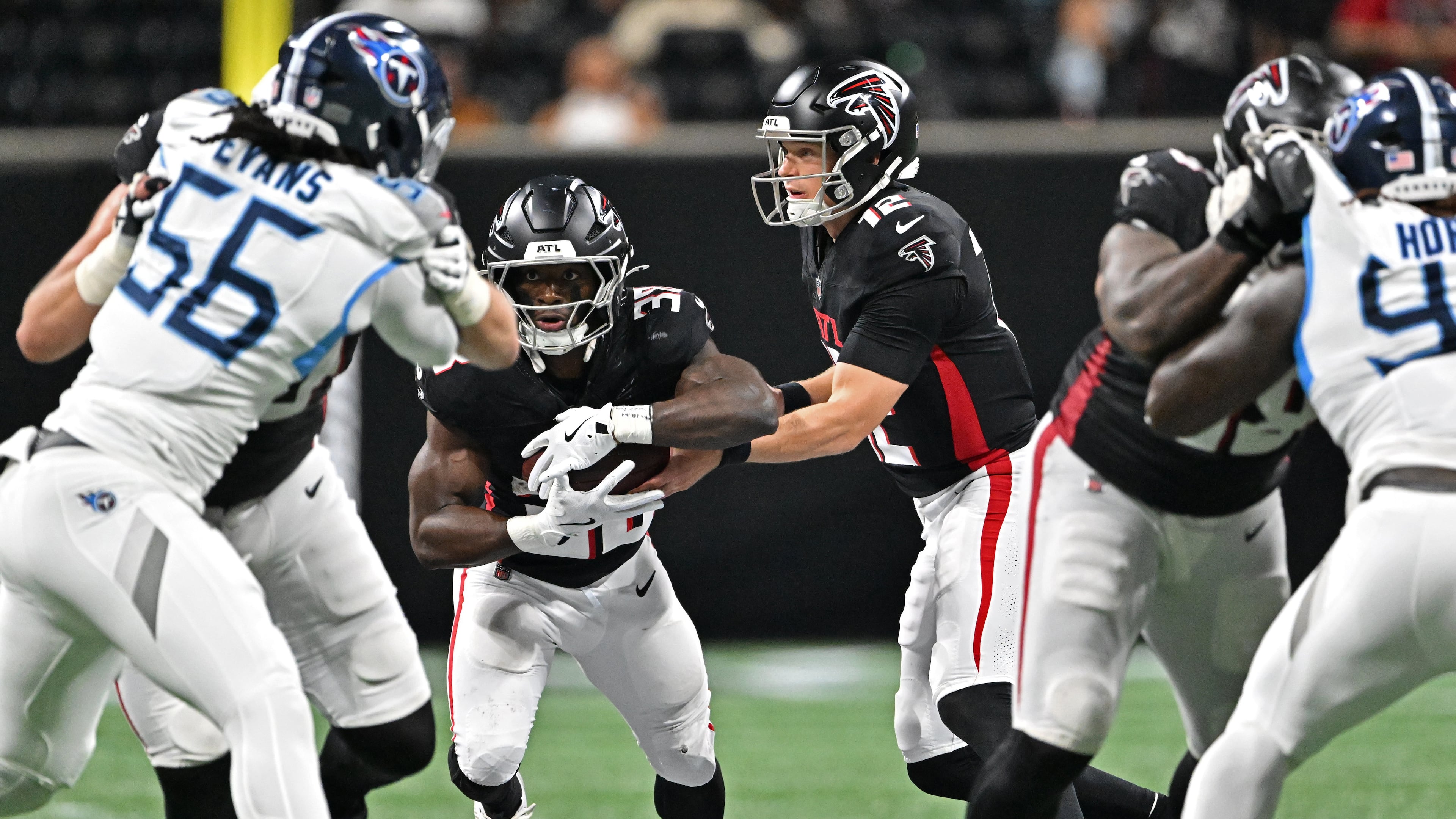Falcons quarterback Easton Stick (right center) hands off to Nathan Carter during the second half Friday, Aug. 15, 2025, at Mercedes-Benz Stadium in Atlanta. Carter rushed for 63 yards on nine carries, with a touchdown. (Hyosub Shin / AJC)