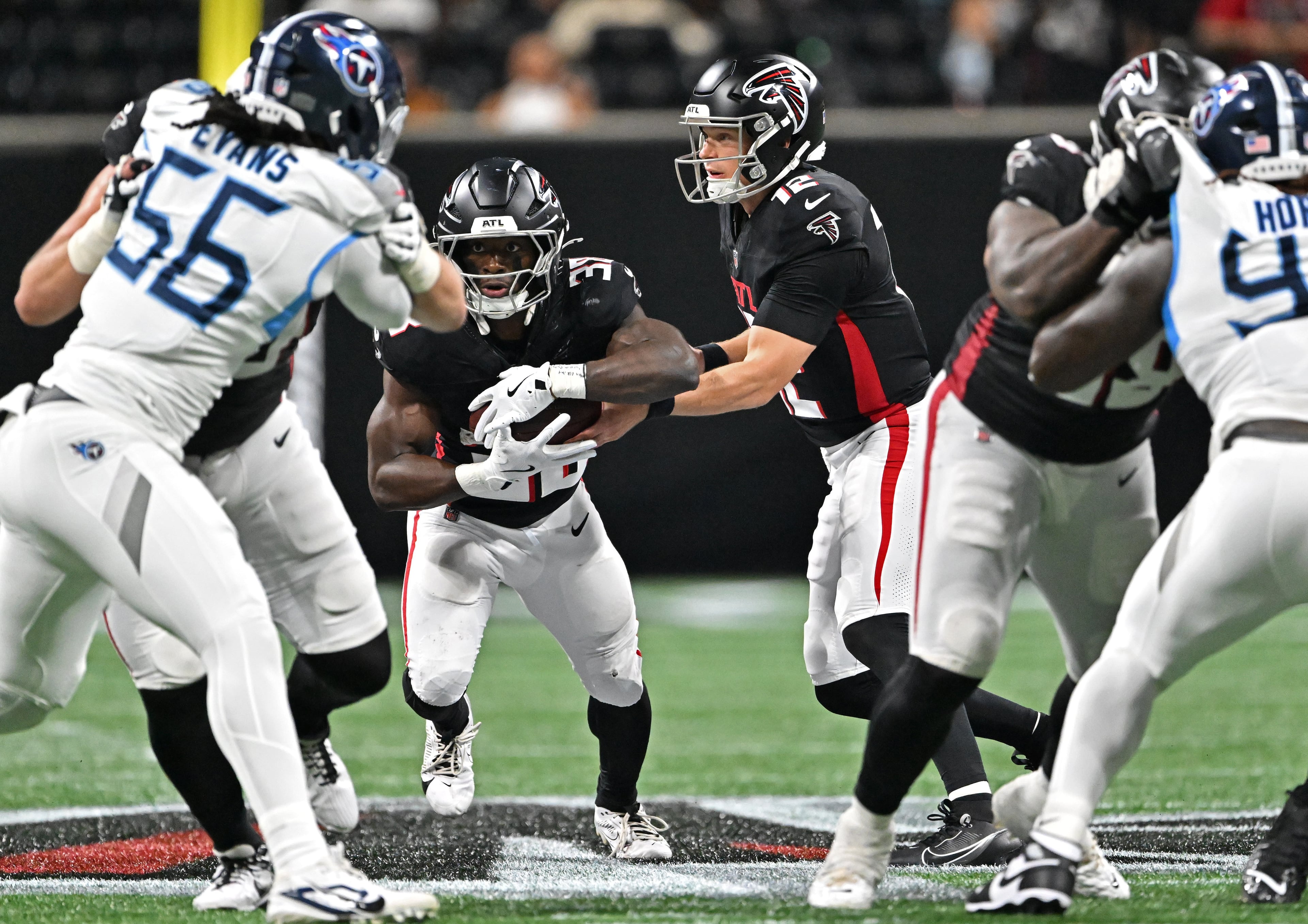 Atlanta Falcons quarterback Easton Stick makes a handoff to Atlanta Falcons running back Nathan Carter during the second half of an NFL preseason game at Mercedes-Benz Stadium, Friday, August 15, 2025, in Atlanta. (Hyosub Shin/AJC)