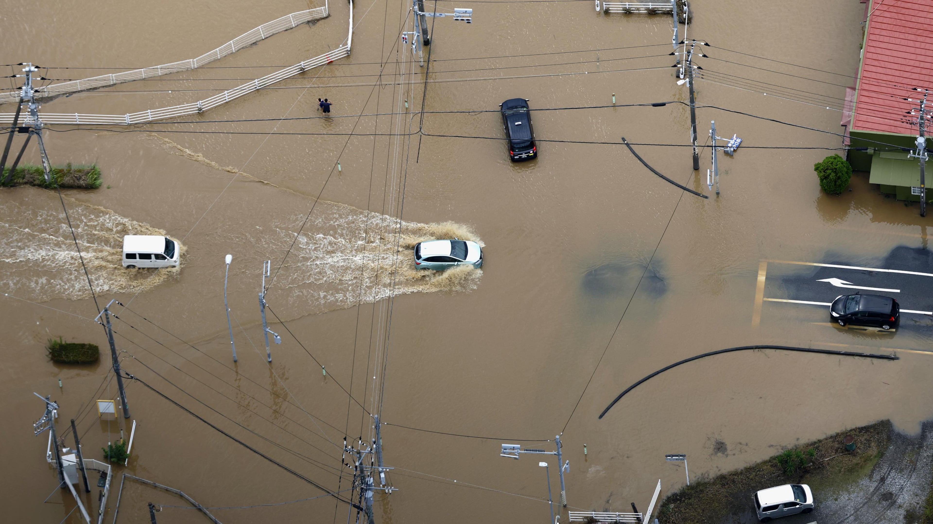 Cars make their way through flooded road after heavy rain in Oamishirasato, Chiba prefecture, Japan, Friday, Aug. 14, 2026. (Kota Endo/Kyodo News via AP)