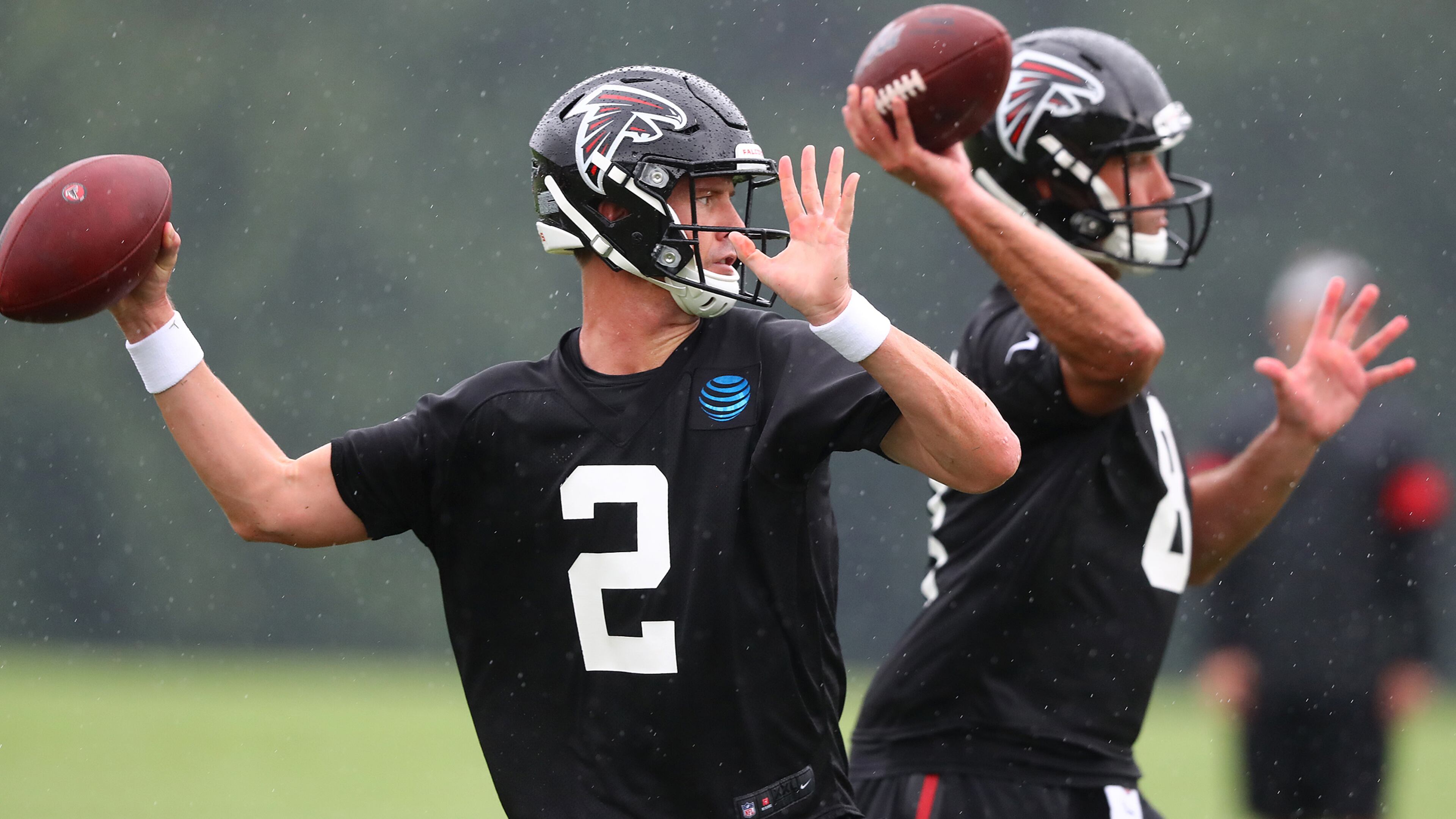 Falcons quarterback Matt Ryan and backup quarterback Matt Schaub (background) pass during pass route drills in the second practice of training camp Tuesday, July 23, 2019, in Flowery Branch.