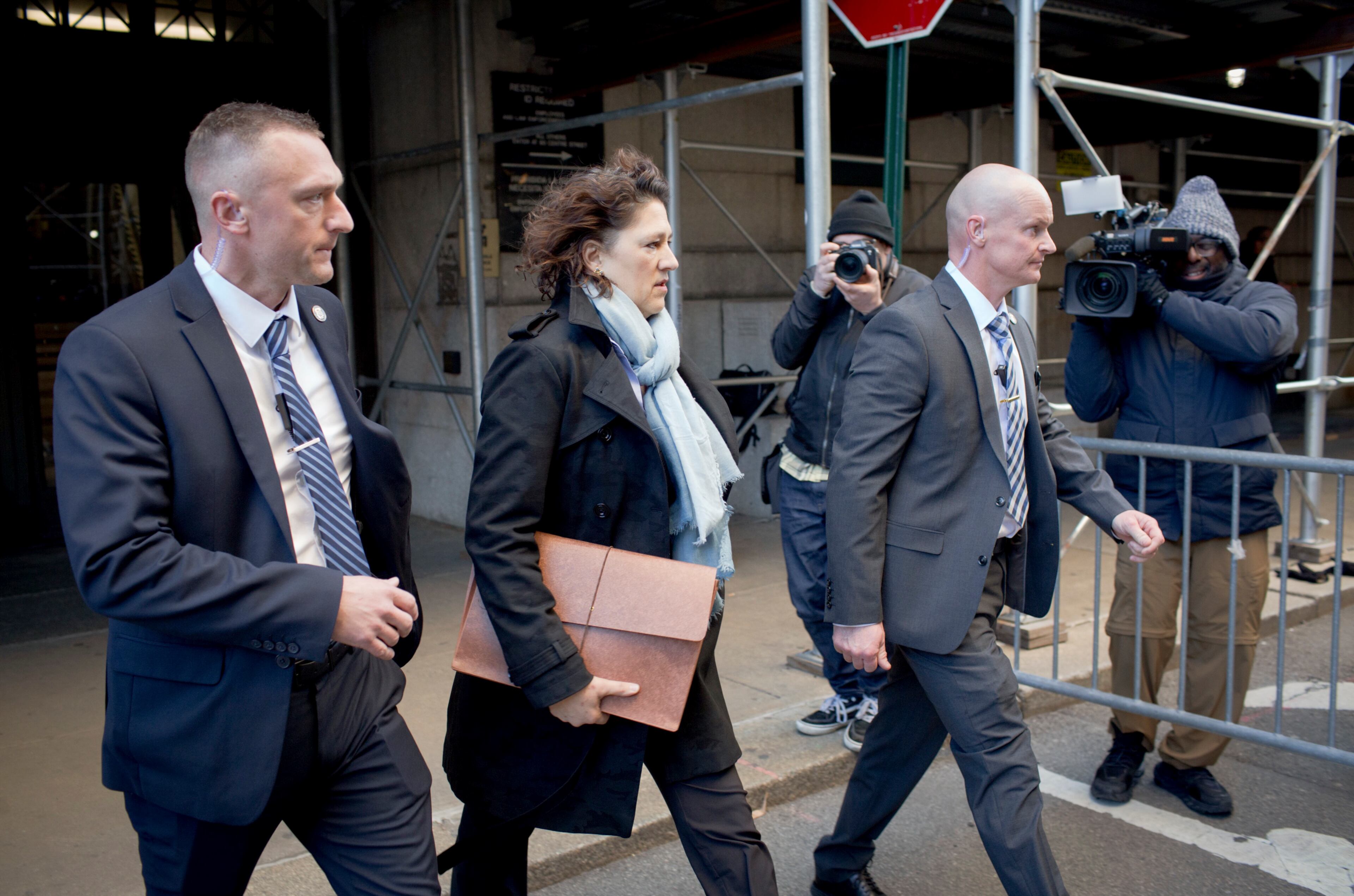 Susan Hoffinger, a prosecutor with the Manhattan district attorney's office, walks with security between Manhattan Criminal Court buildings in Manhattan, March 30, 2023. A Manhattan grand jury voted to indict Donald J. Trump on Thursday for his role in paying hush money to a porn star, according to four people with knowledge of the matter. (Anna Watts/The New York Times)