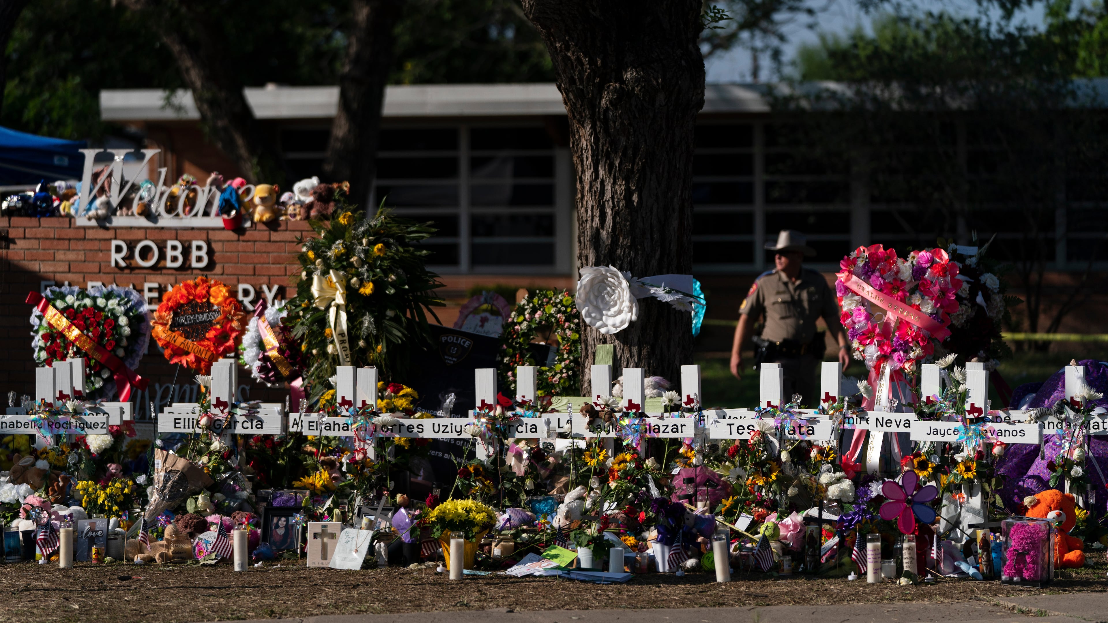FILE - Flowers and candles are placed around crosses to honor the victims killed in a school shooting, May 28, 2022, outside Robb Elementary School in Uvalde, Texas. (AP Photo/Jae C. Hong, File)
