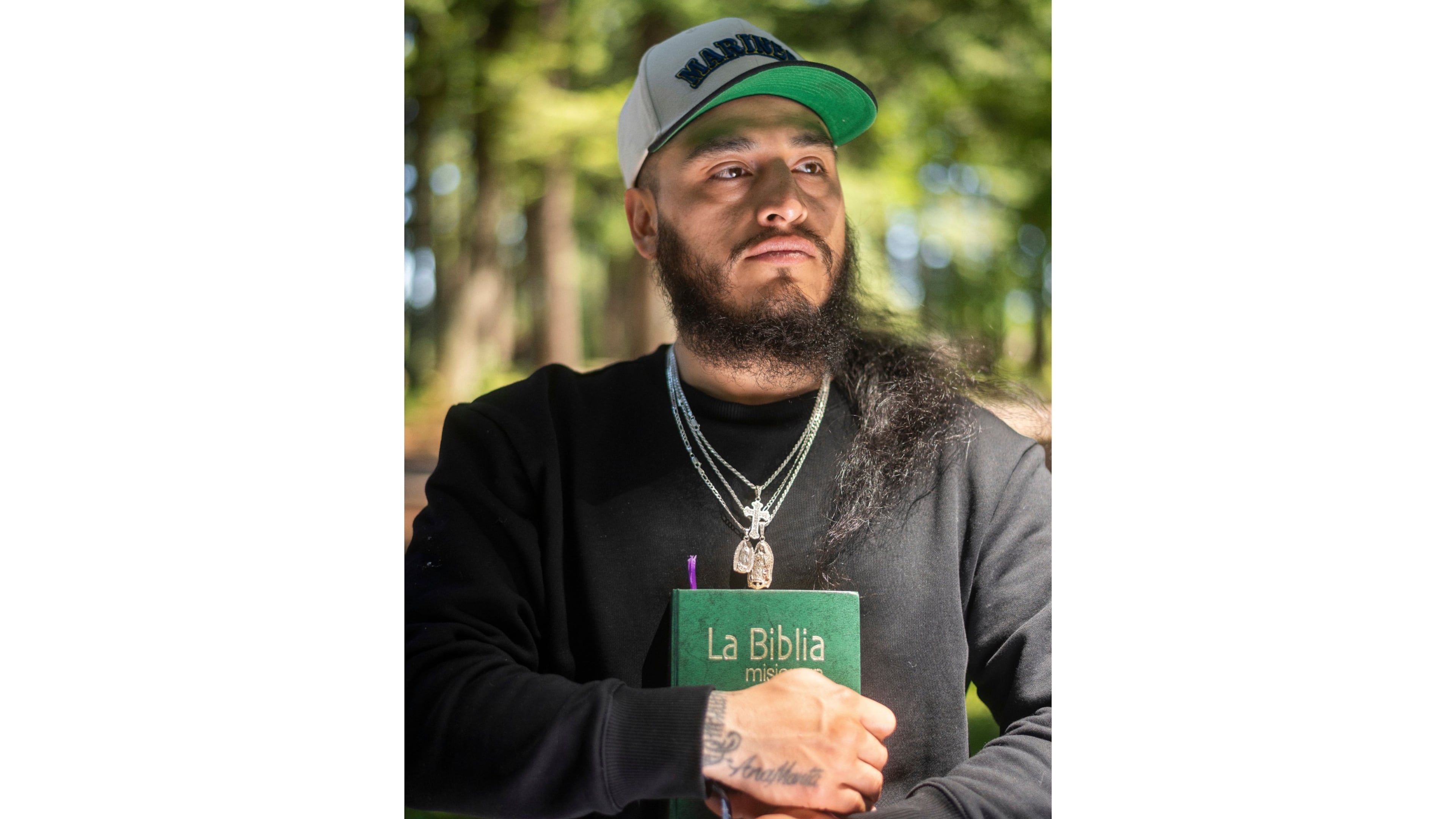 Gabriel Martinez Garcia, 30, holds a Bible close to his chest as tattoos of his parents are visible on his wrists, in Tenino, Wash., on Sunday, June 14, 2026. (AP Photo/Akash Pamarthy)