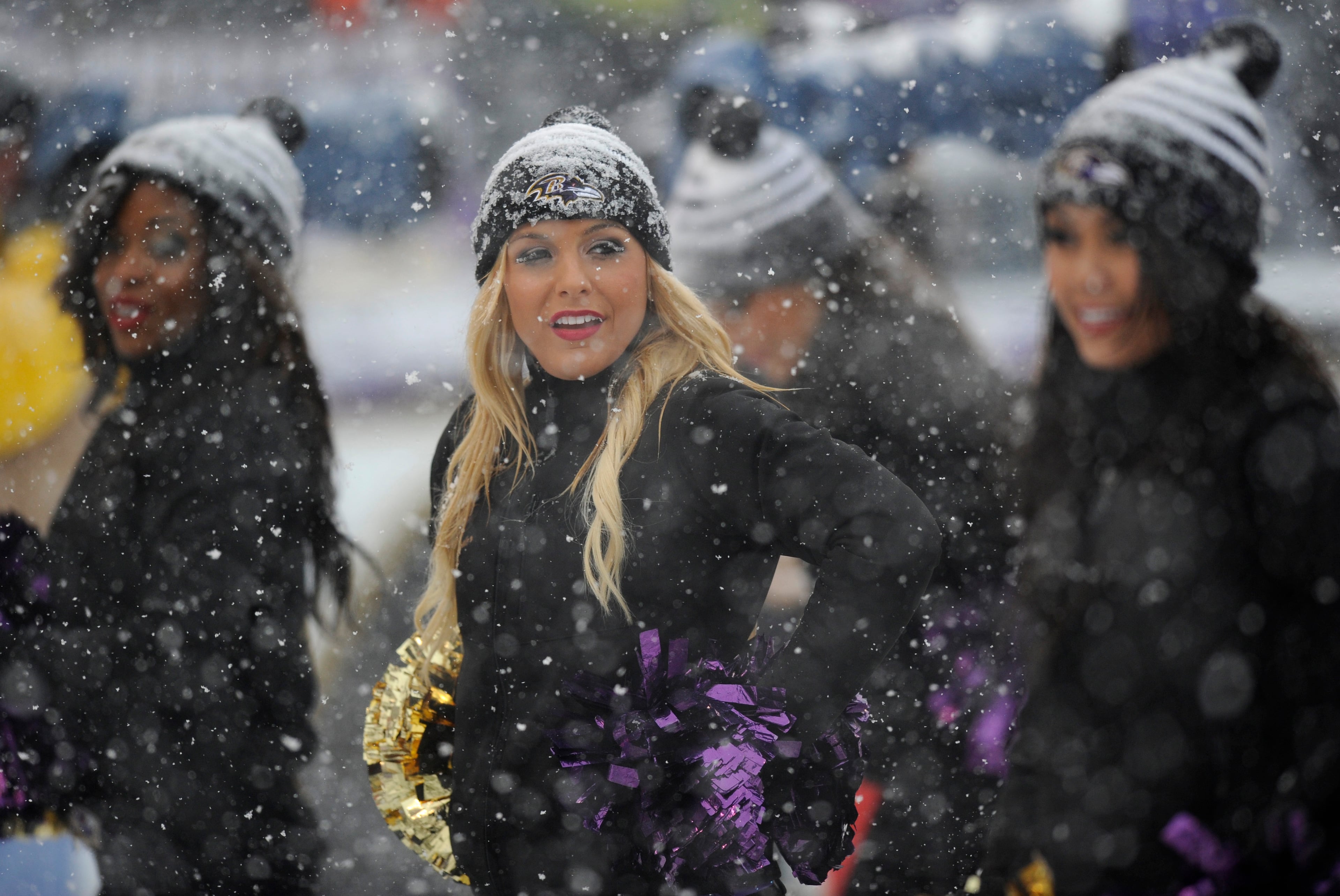Baltimore Ravens cheerleaders stand on the sidelines as snow falls in the first half of an NFL football game against the Minnesota Vikings on Dec. 8, 2013, in Baltimore.