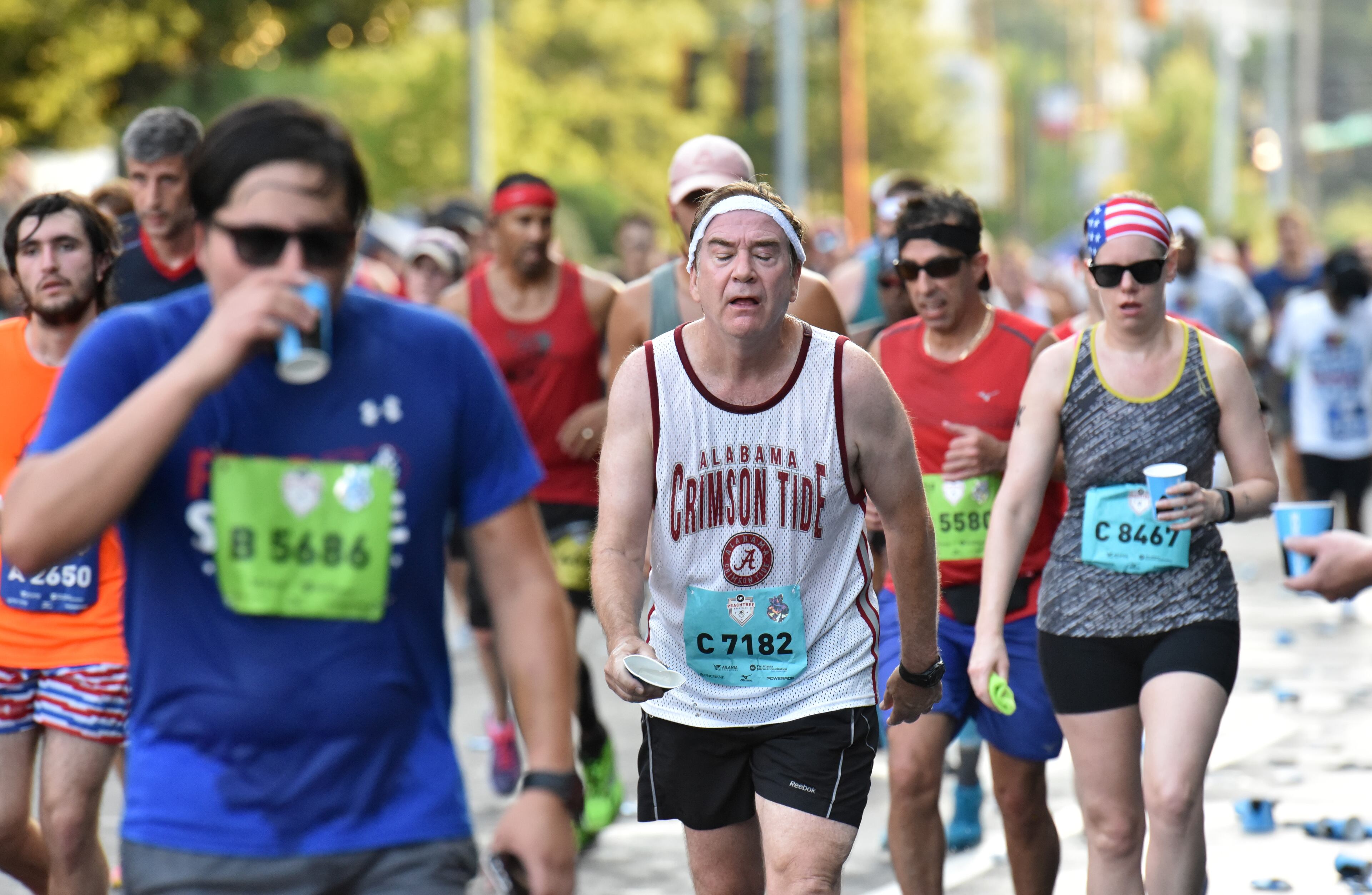 July 4, 2018 Atlanta - Runners cool off at a water station on the top of Cardiac Hill during the AJC Peachtree Road Race on Wednesday, July 4, 2018. HYOSUB SHIN / HSHIN@AJC.COM