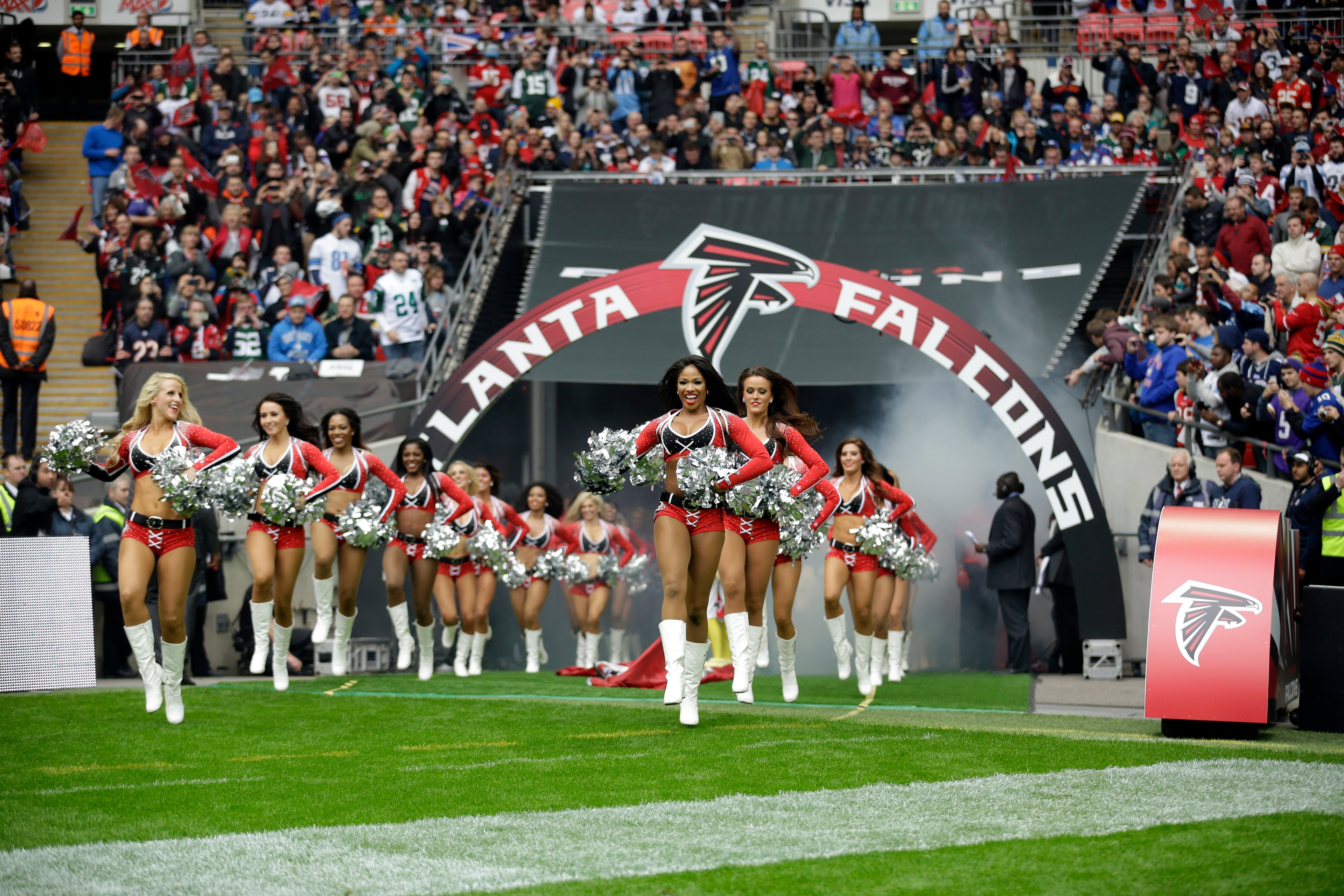Atlanta Falcons cheerleaders run to the field before the NFL football game between the Atlanta Falcons and the Detroit Lions at Wembley Stadium, London, Sunday, Oct. 26, 2014. (AP Photo/Matt Dunham)