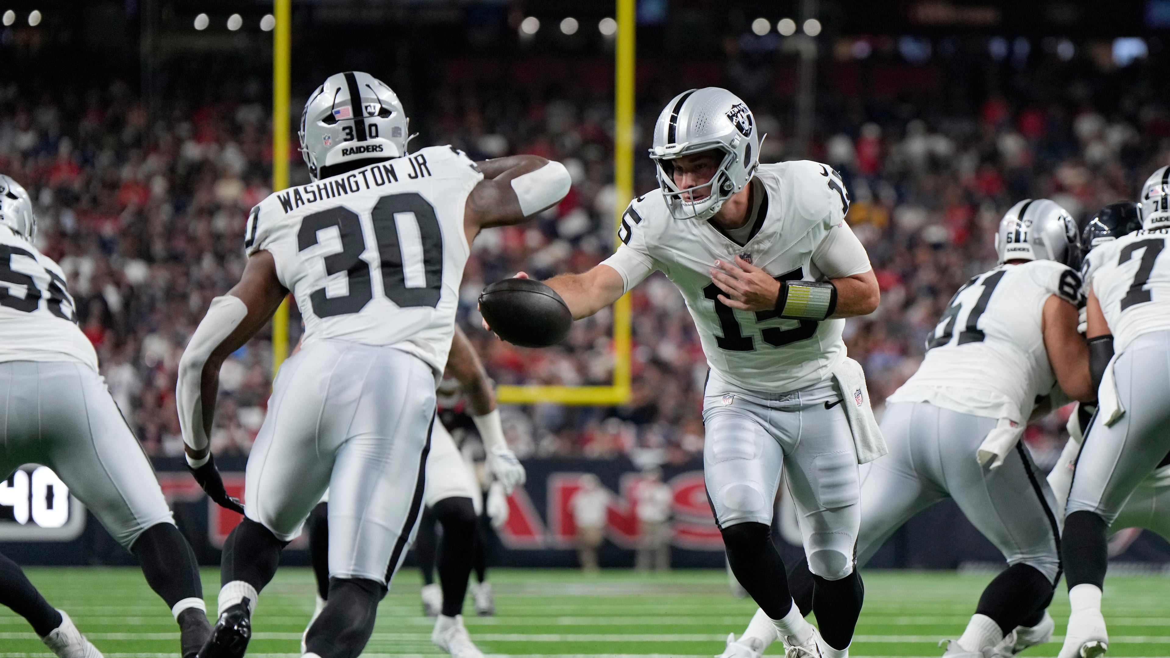 Las Vegas Raiders quarterback Fernando Mendoza (15) hands off to Las Vegas Raiders running back Mike Washington Jr. (30) during the first half of an NFL preseason football game against the Houston Texans, Thursday, Aug. 20, 2026, in Houston. (AP Photo/Ashley Landis)