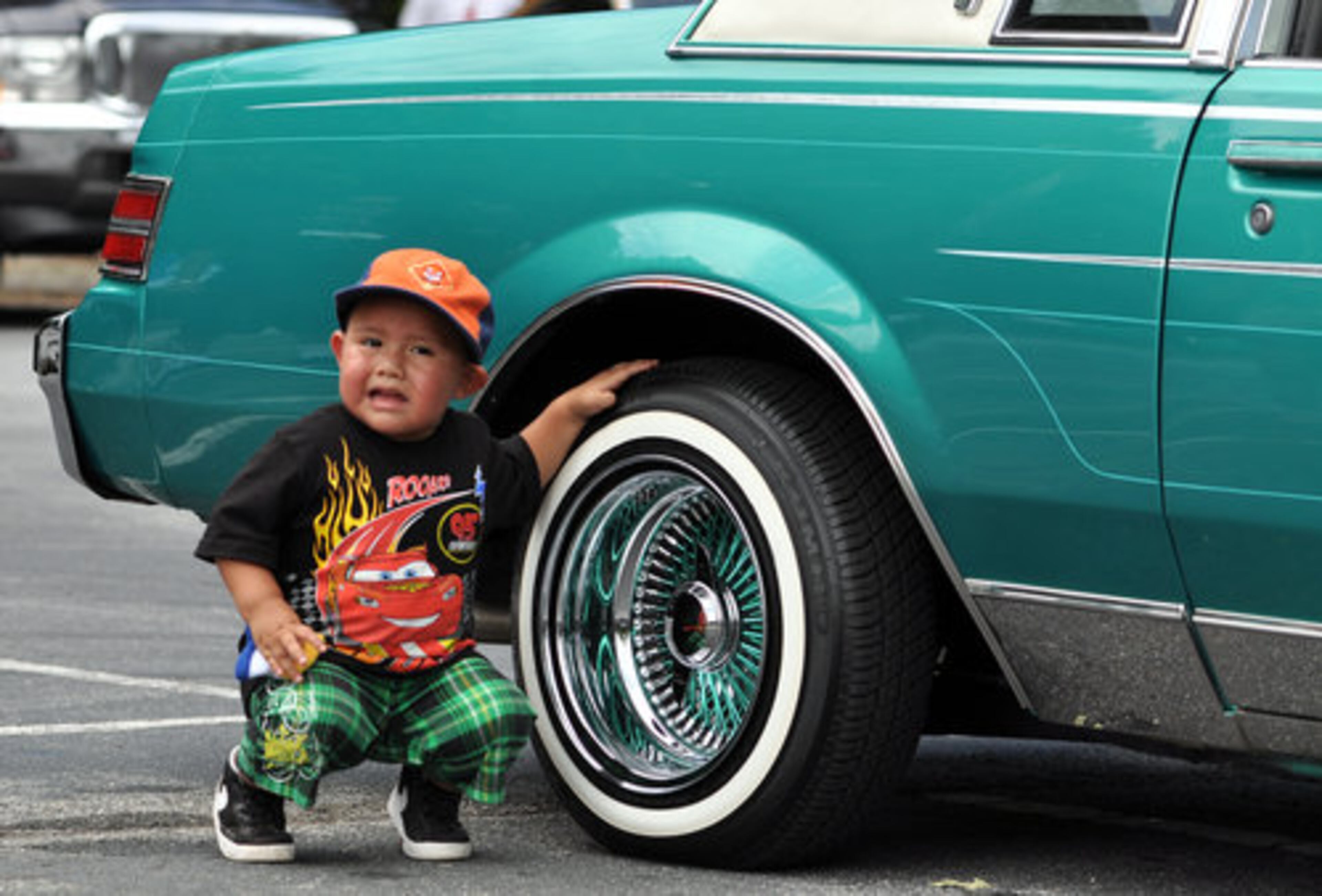 Two-year-old Jayden Mondragon checks out the tires and rims on one of his favorite cars at the Spaghetti Junction Car and Bike Show at Club Europe in Doraville Saturday, August 13, 2011.