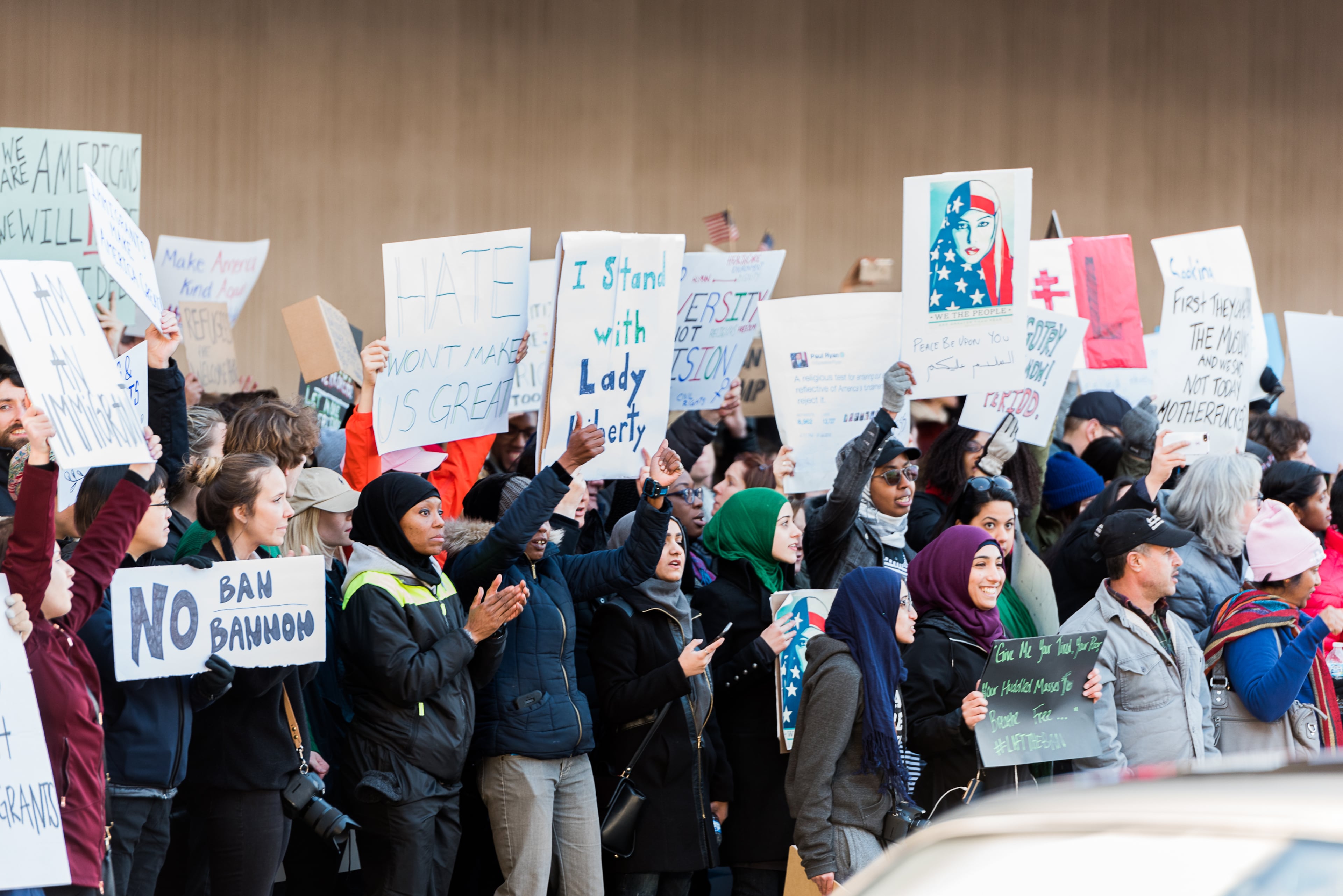 Protesters hold signs as they chant in front of Hartsfield-Jackson International Airport, Sunday, January 29, 2017. (Cory Hancock for The AJC)