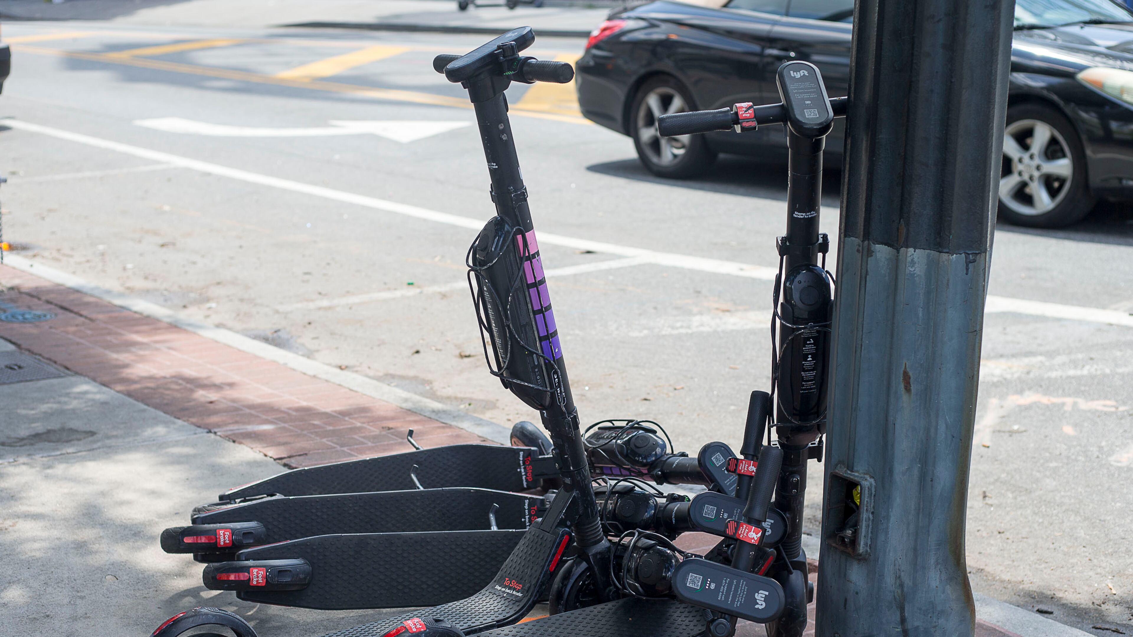 Electric scooters sit piled up on the sidewalk near Centennial Olympic Park in Atlanta. (Alyssa Pointer/alyssa.pointer@ajc.com)