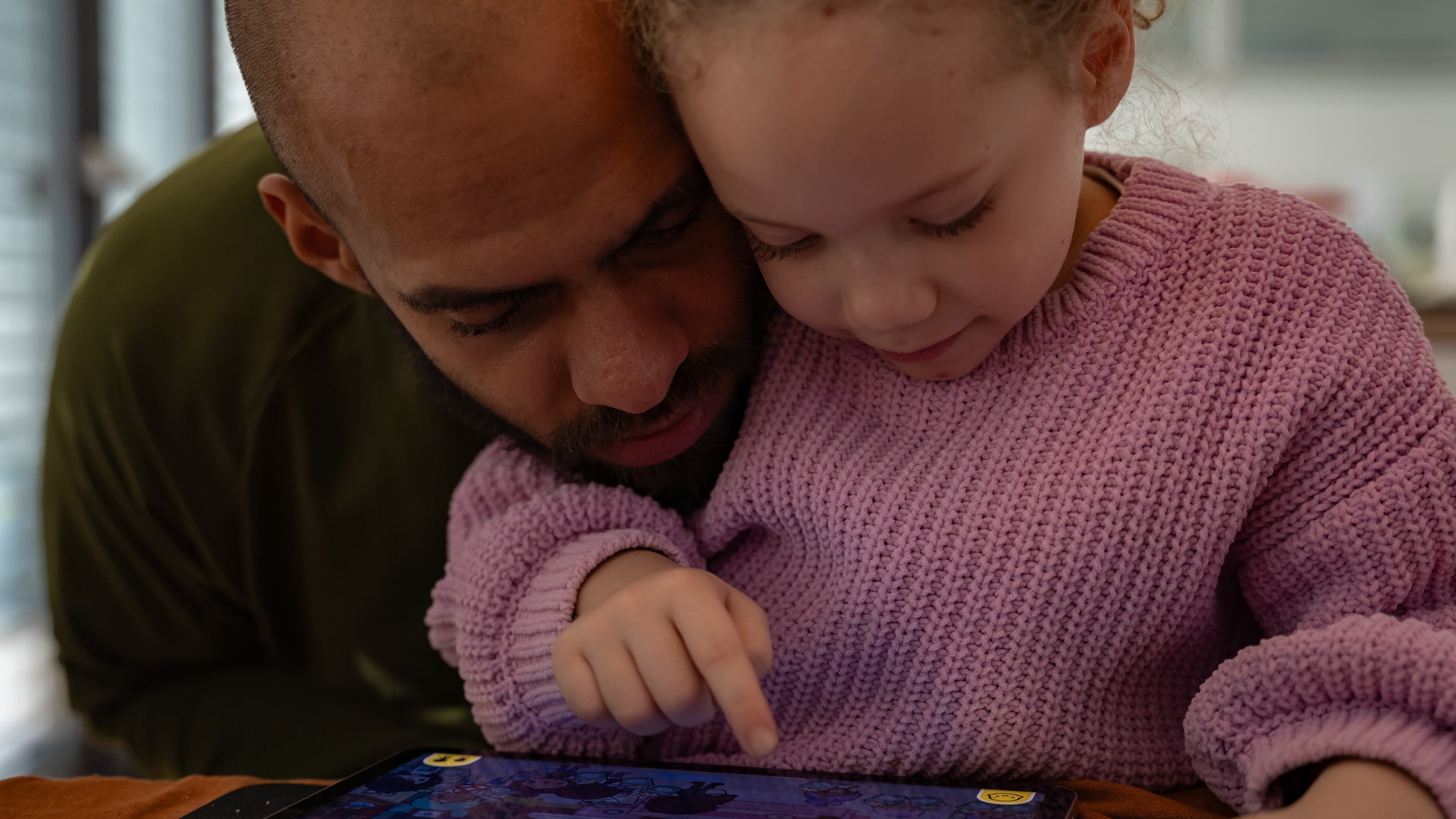 Kasim Edebali and his daughter Yara play a game on a tablet, in Hamburg, Germany. (Patrick Junker/The New York Times 2023)