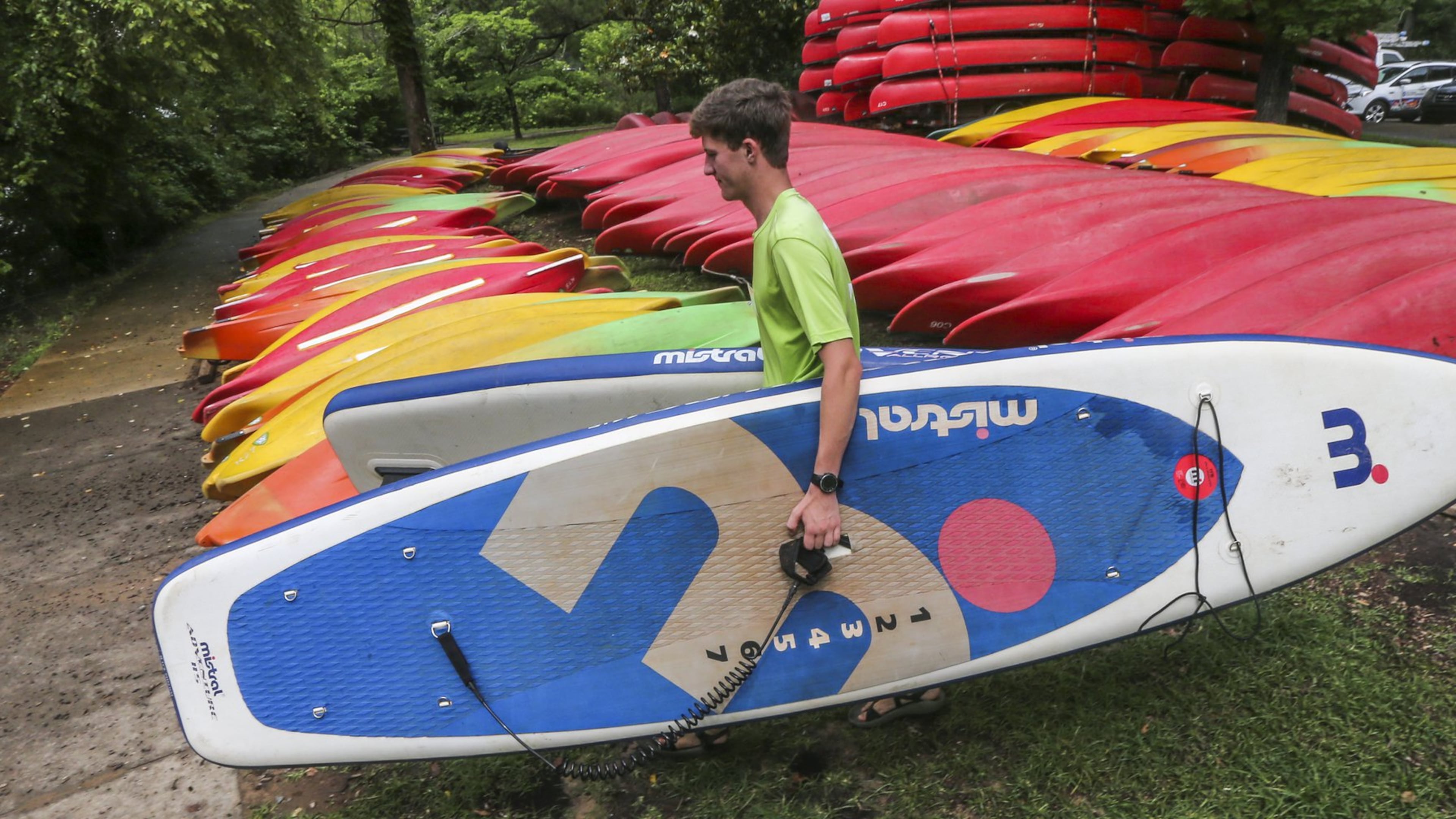Jase Heins, 18, carries some inflatable paddle boards to the Chattahoochee River bank on May 31, 2017 at Shoot The Hooch, where river goers could rent water vessels. JOHN SPINK/JSPINK@AJC.COM.