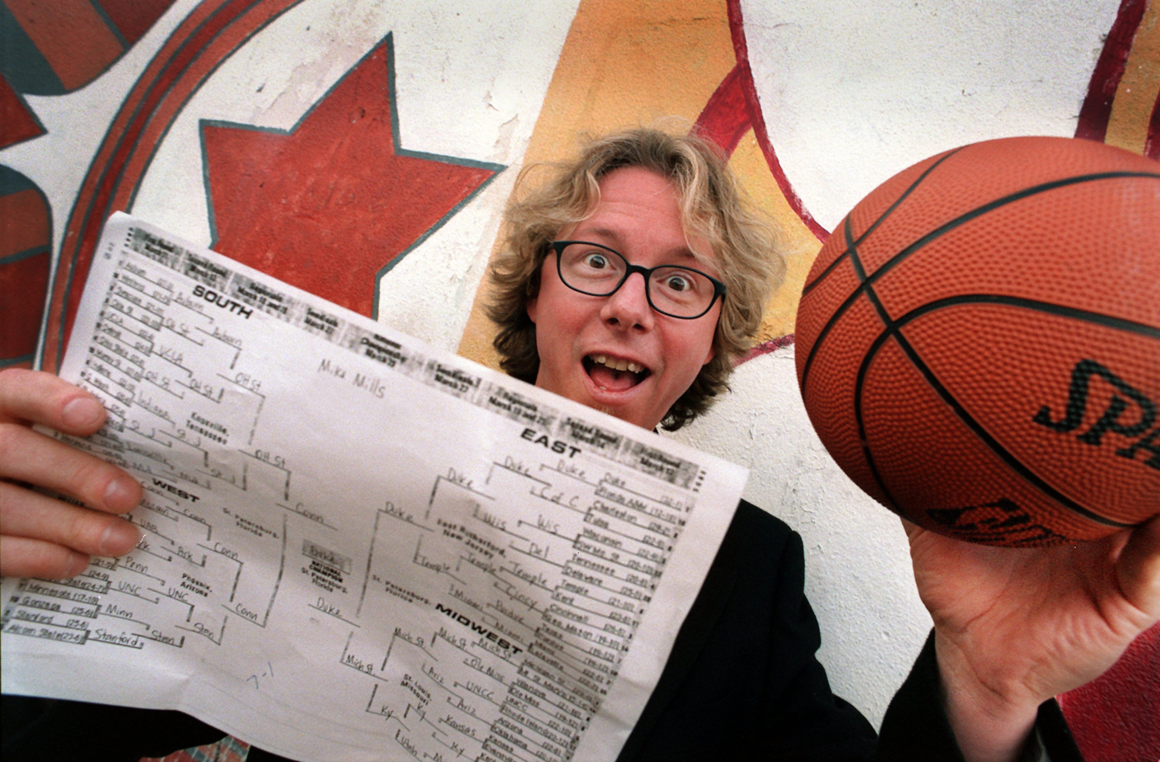 Bassist/keyboardist Mike Mills of the band R.E.M. won the Mark Bradley Final Four Picks. Shown here with his entry form and basketball.