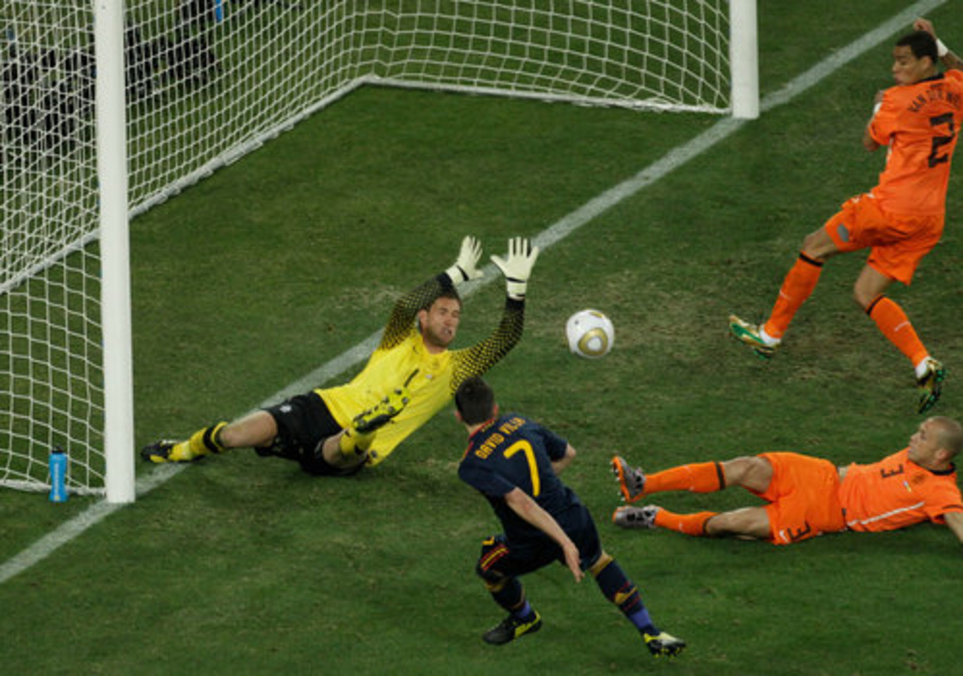 Spain's David Villa, bottom, misses a scoring chance as Netherlands goalkeeper Maarten Stekelenburg, left, Netherlands' John Heitinga, right, and Netherlands' Gregory van der Wiel, go to block his shot.